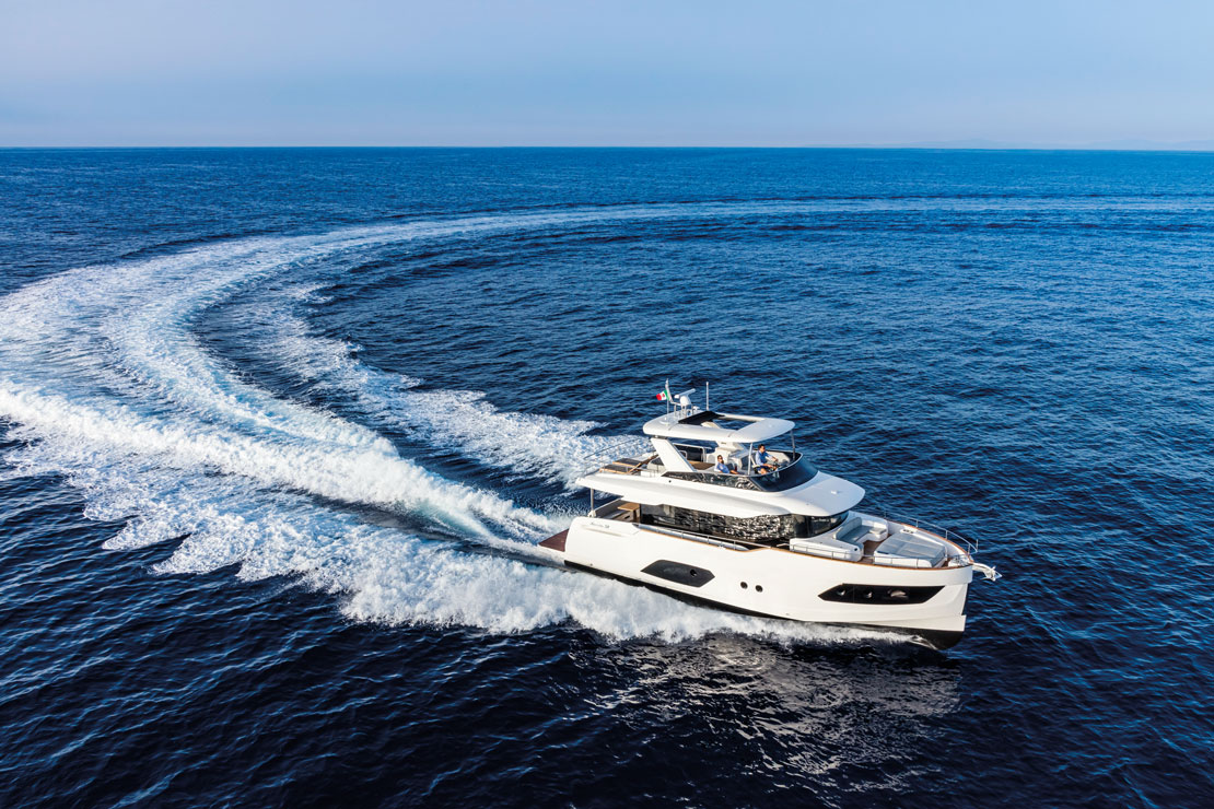 The Navetta 58 turning at speed on open water, her wake curving away astern.