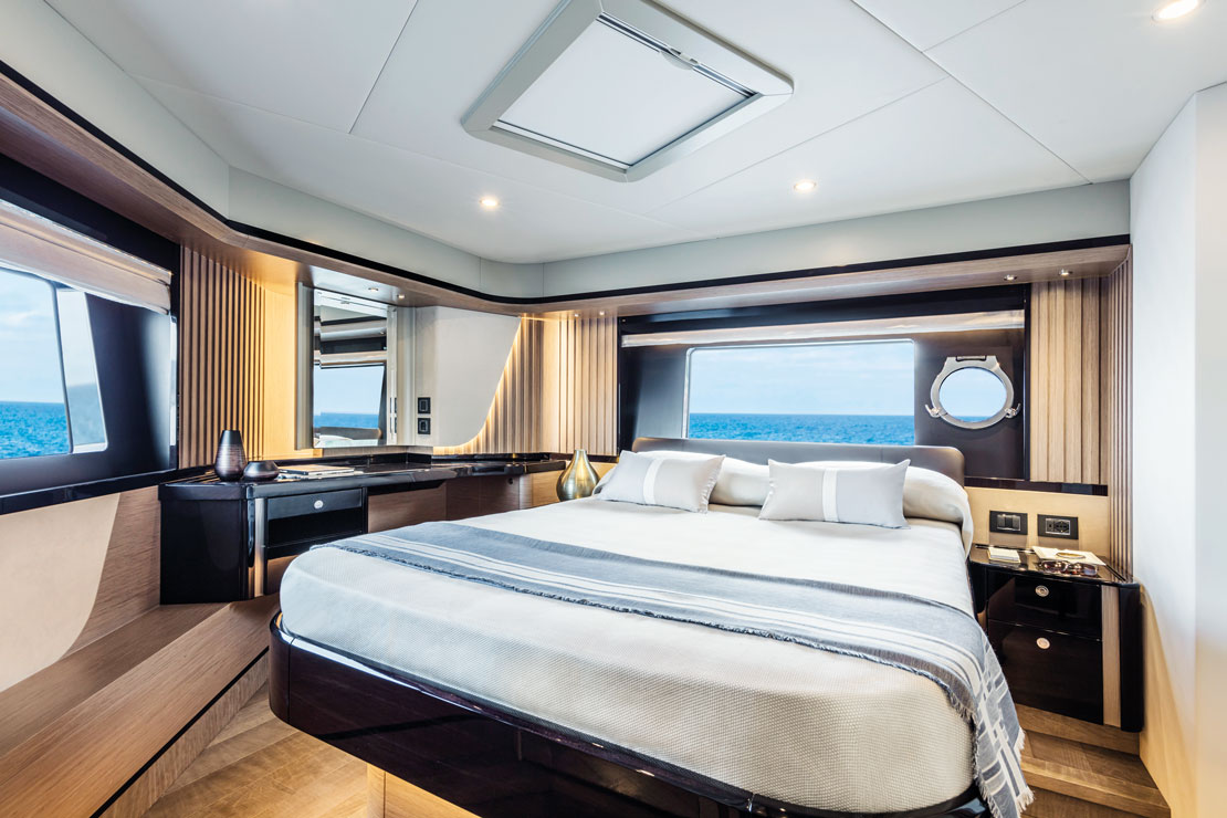 The master cabin, with a double berth, a desk to port and hull windows either side.