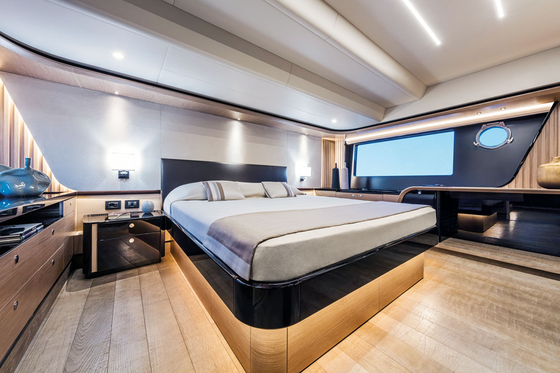 A guest cabin with a double berth against the hull side, lit by a hull window and porthole.