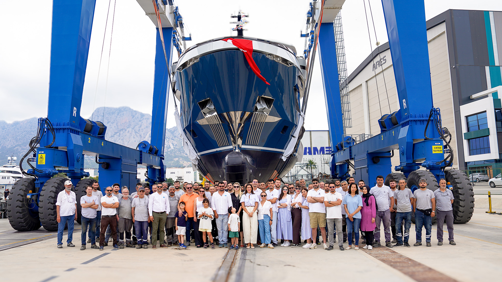 M/Y V in a travel lift at launch with the shipyard crew assembled in front