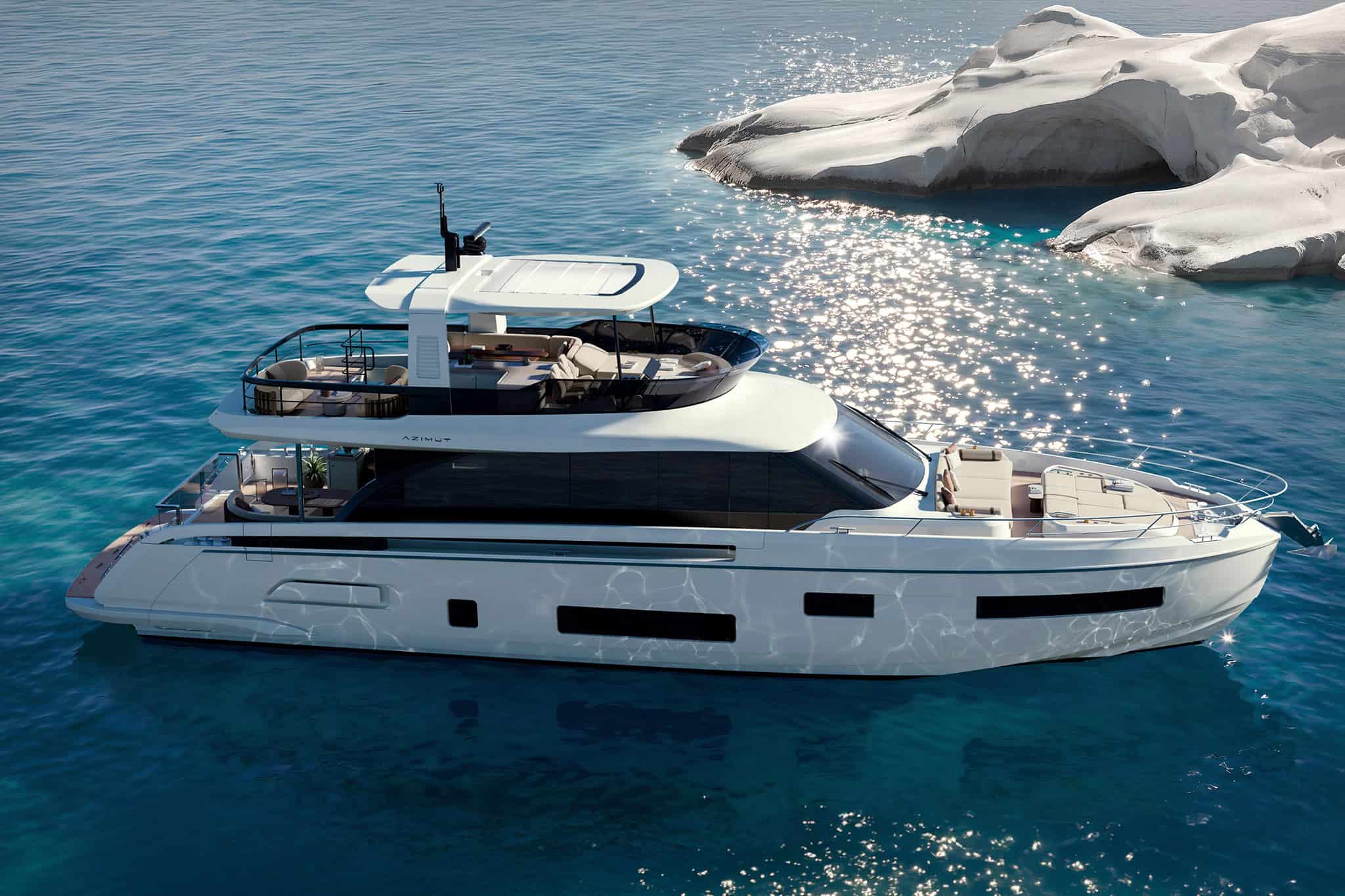 The Fly 70 seen from above and to one side at anchor, the flybridge seating and helm visible under the hardtop and the foredeck sunpads forward, white rocks behind her