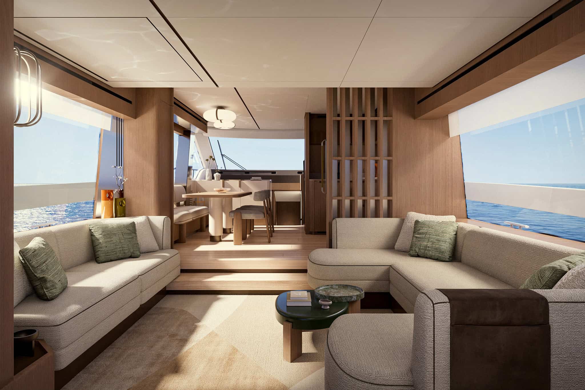 The main deck saloon looking forward, pale sofas either side of a dark green low table on a light rug, a slatted timber screen to the right and the dining table on a raised level beyond