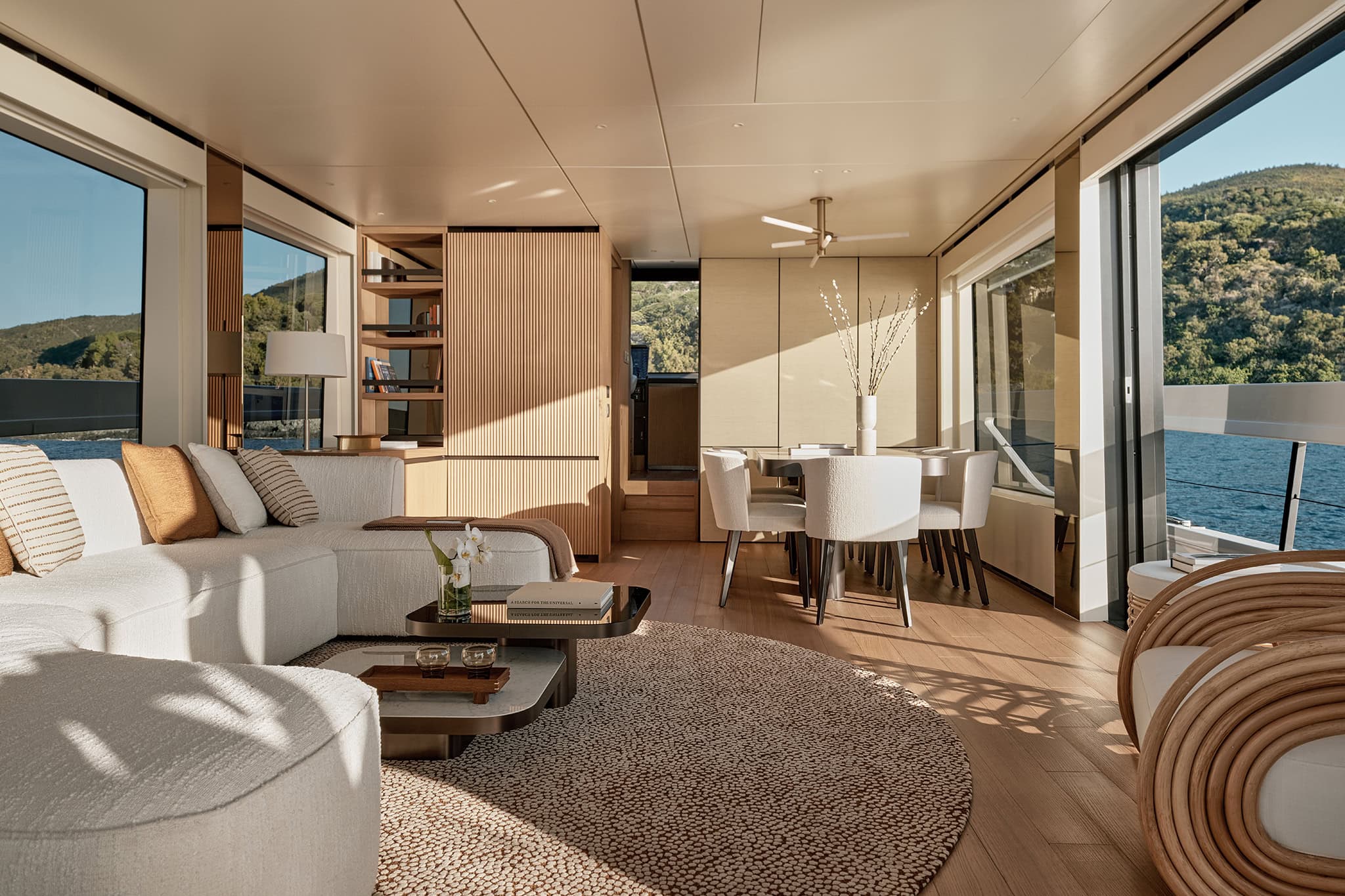 Main deck saloon with seating, dining area and full-height glazing