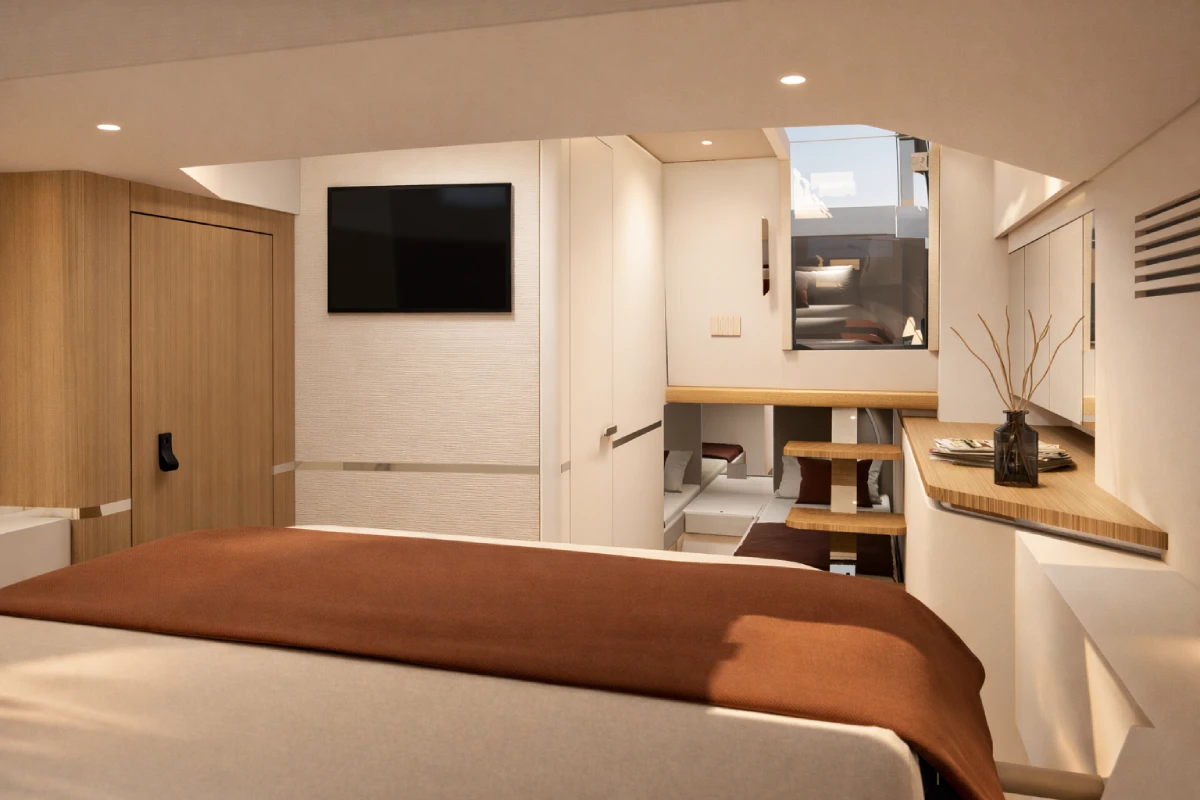 A cabin with a double berth, a wall-mounted screen and steps rising to the deck above.