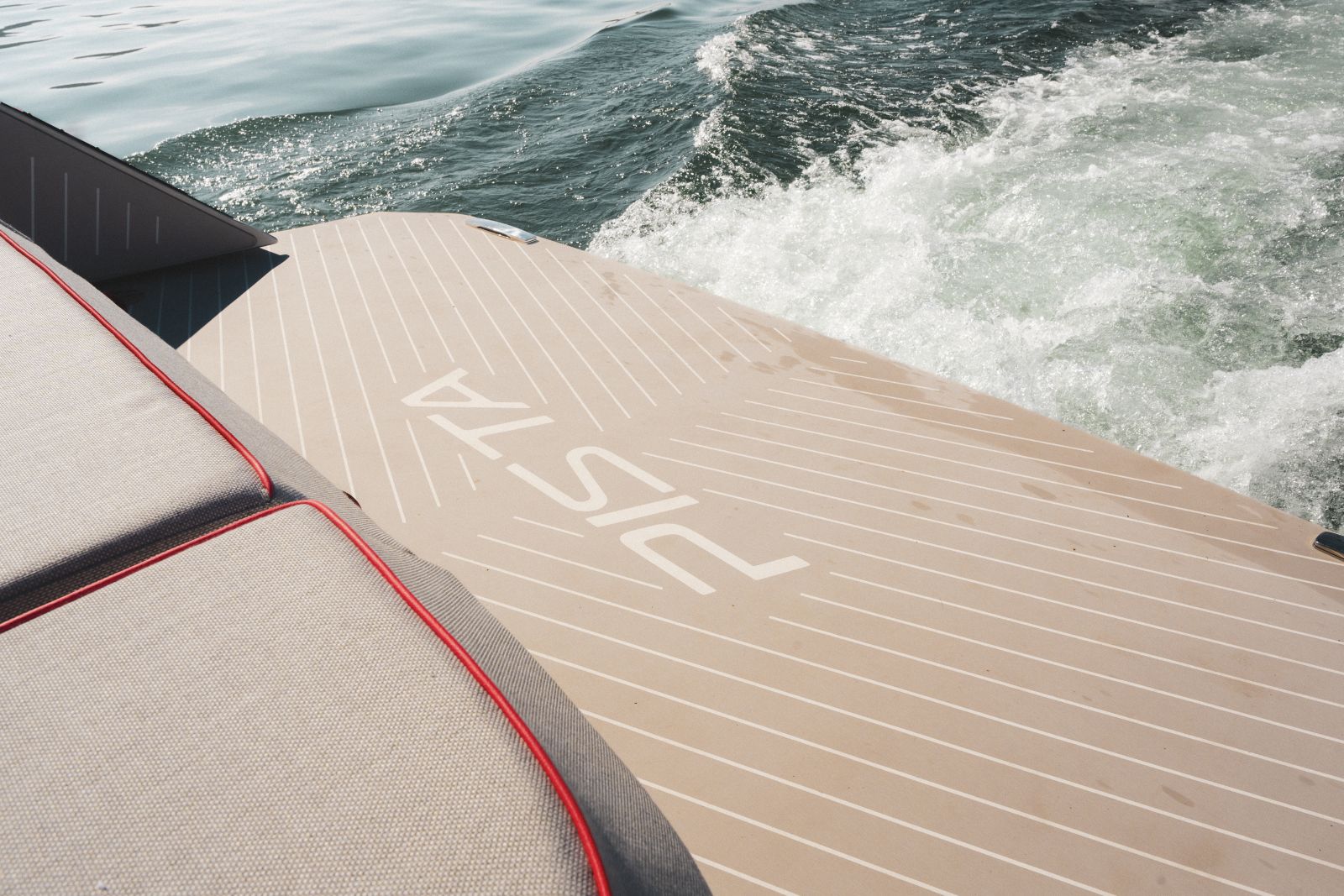 The teak bathing platform with PISTA inlaid into the decking, the wake running out astern.