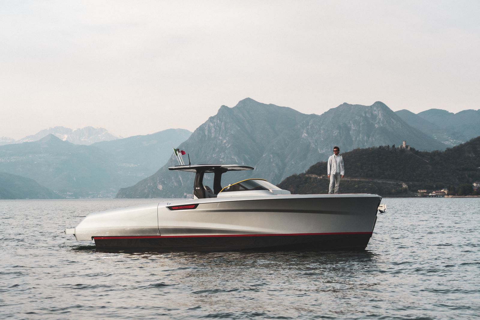 The Astor 38 Pista at rest on the lake in full profile, a figure standing on the foredeck.