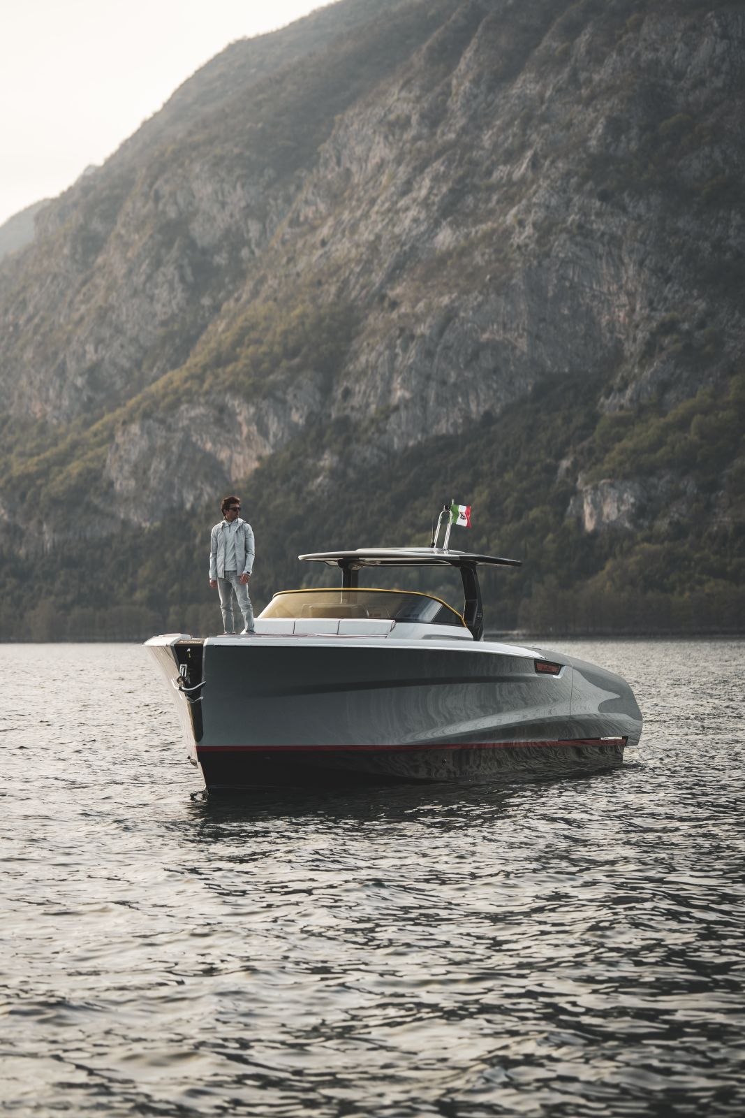 The Astor 38 Pista lying beneath a steep rock face, a figure standing on the foredeck.