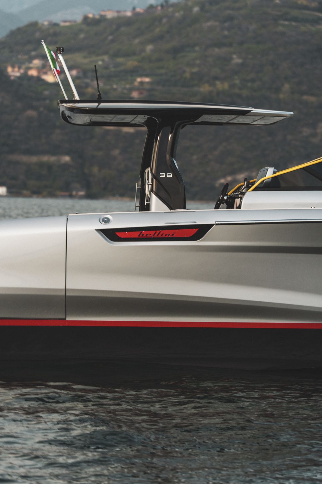 The starboard side amidships, showing the red bellini graphic, the red waterline stripe and the 38 badge on the T-top support.