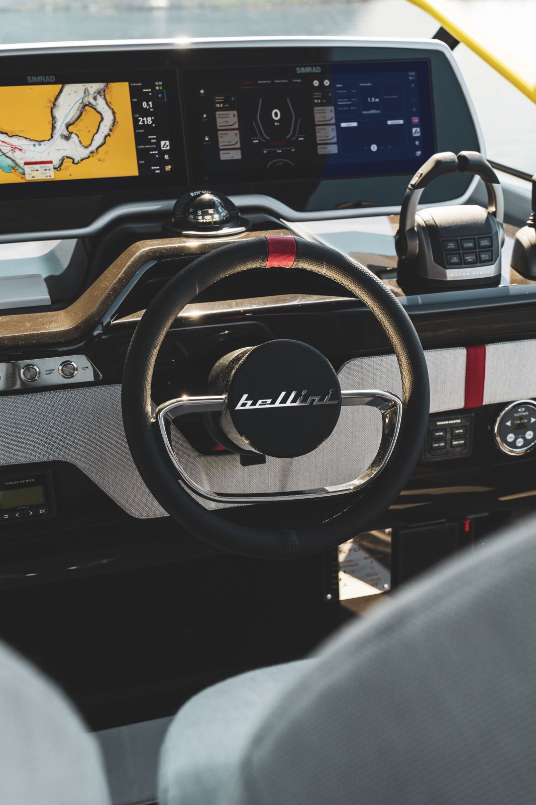 The helm, with the bellini-badged wheel in front of twin Simrad displays and the throttle controls to starboard.
