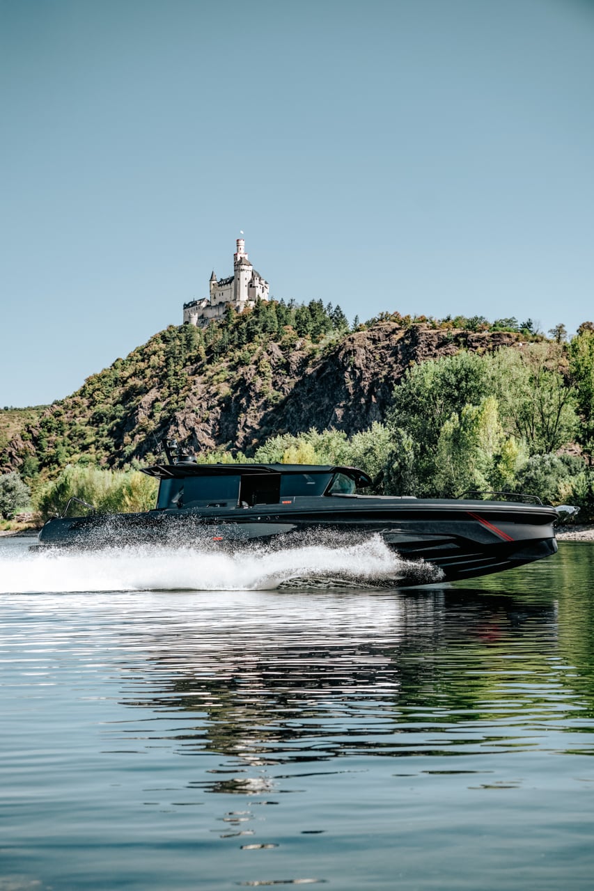 The boat running below a hilltop castle