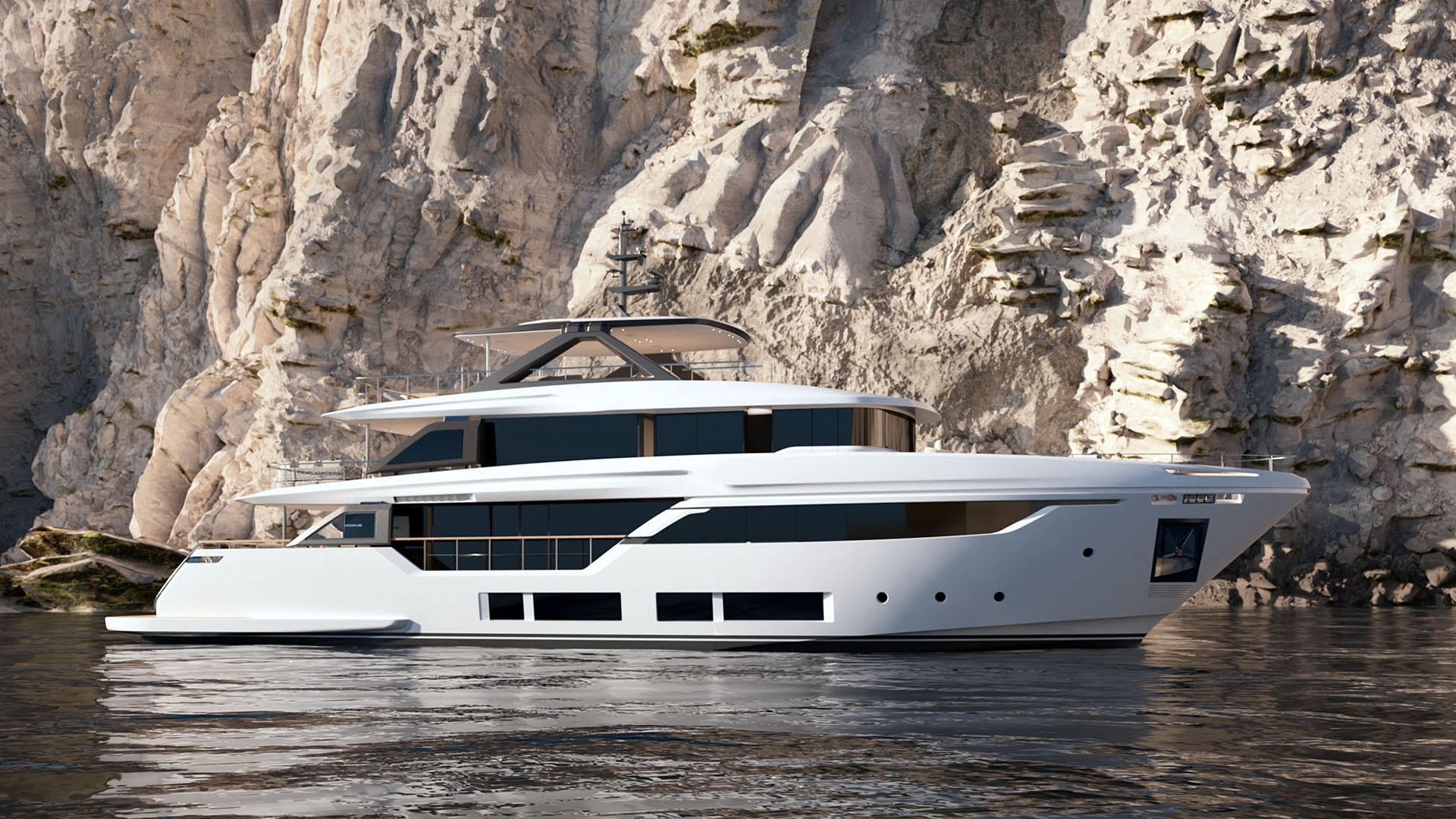 The Navetta 35 lying still against a pale limestone cliff, seen side on: three white decks with dark glazing, a shaded upper deck and a broad swim platform aft