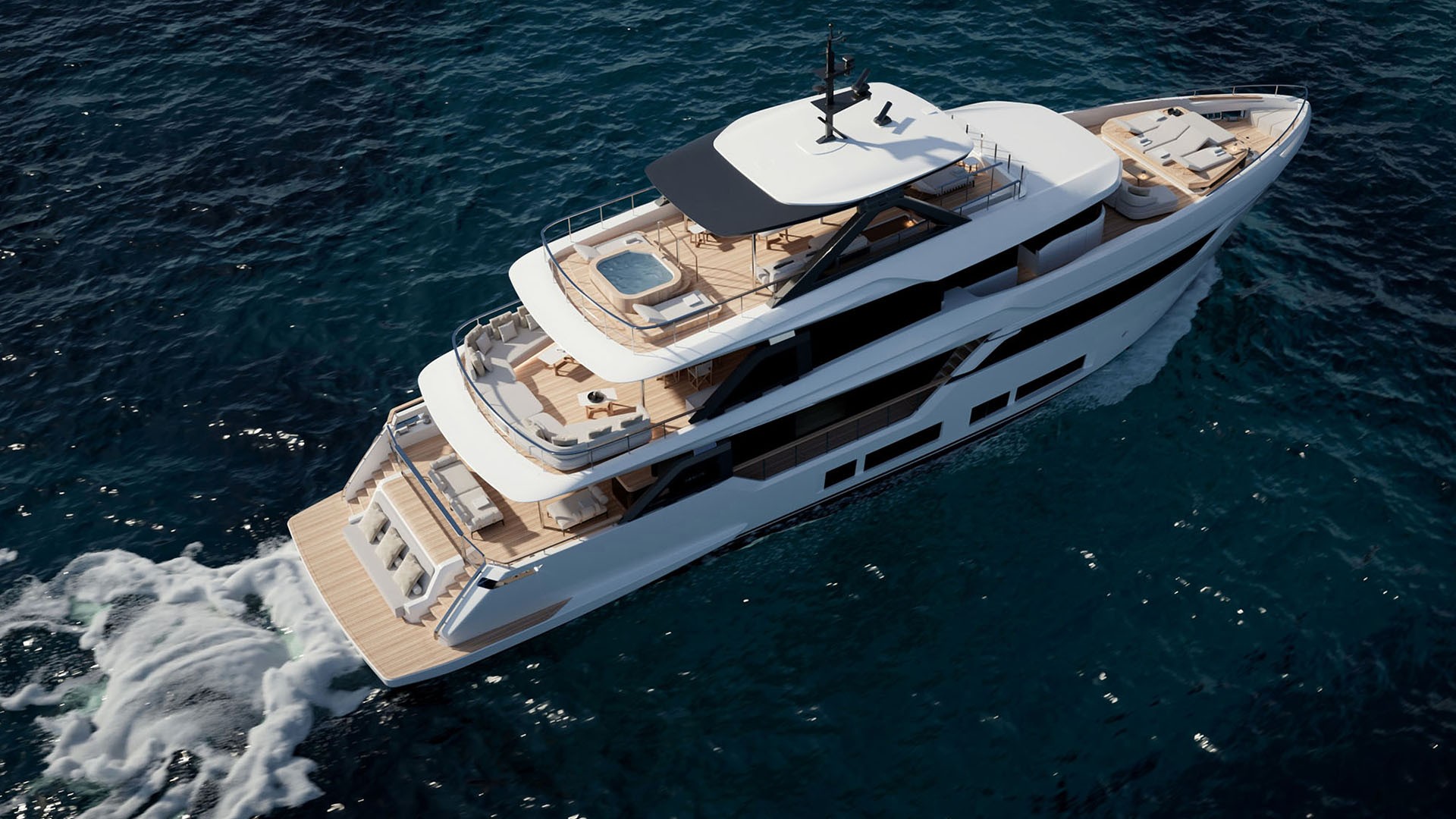 The Navetta 35 photographed from above and astern while under way, showing the stepped aft decks, the shaded sun deck with its spa pool and the sunpads on the foredeck