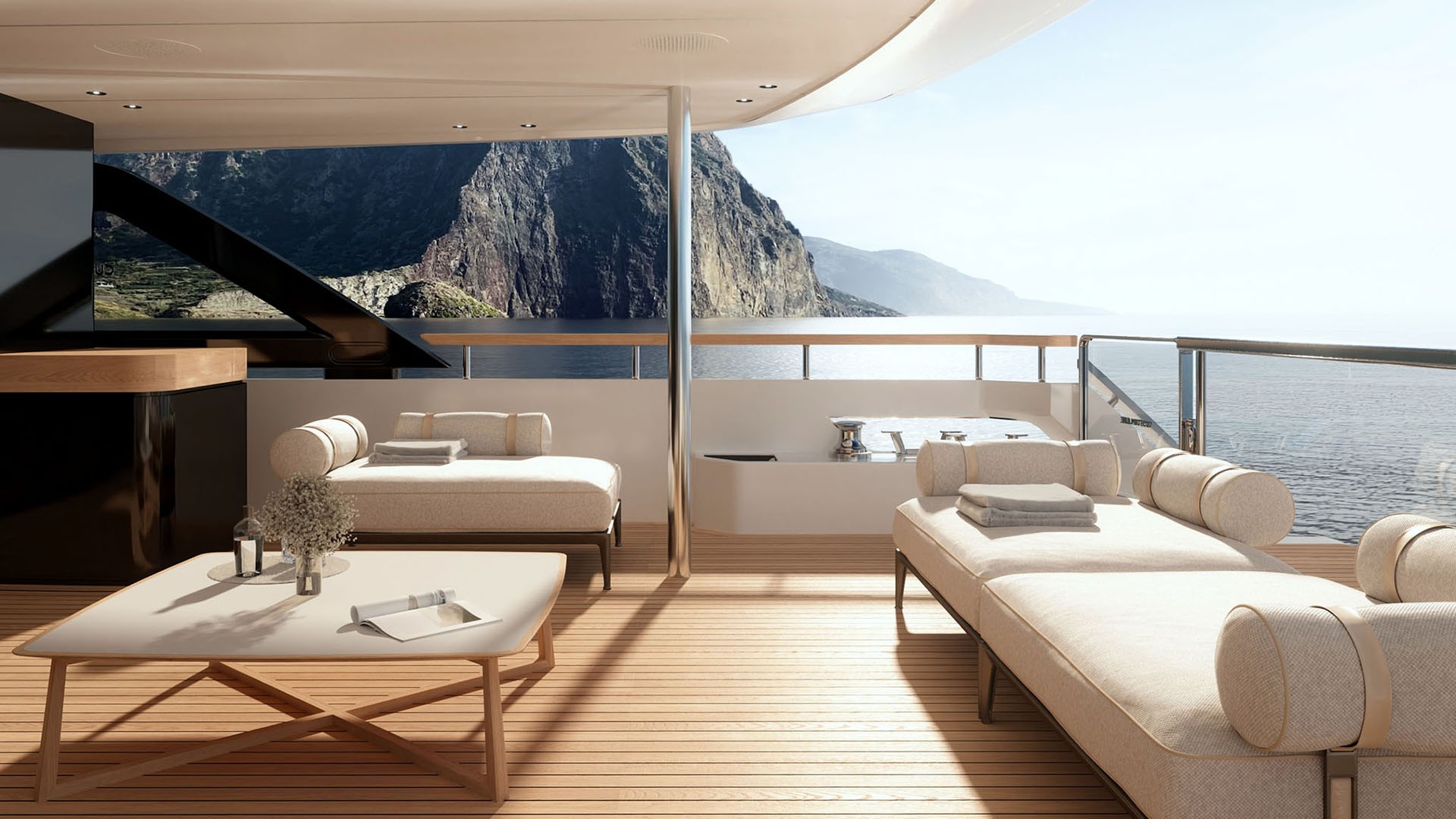 A shaded deck lounge with two daybeds and a low table on a pale teak floor, opening to the sea through an open side with a cliff coastline beyond