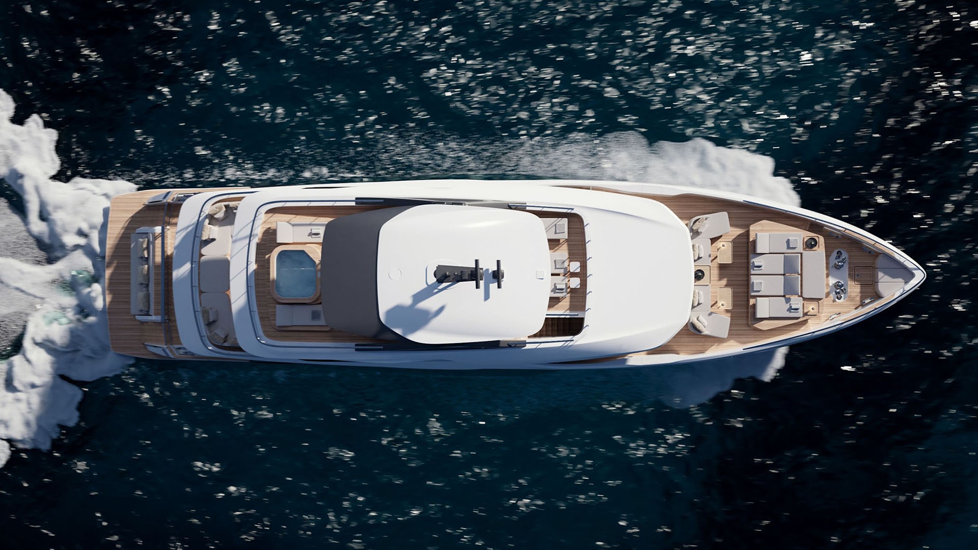 The whole yacht seen from directly overhead under way, the spa pool, sun deck seating and foredeck lounges laid out along her length between white wakes
