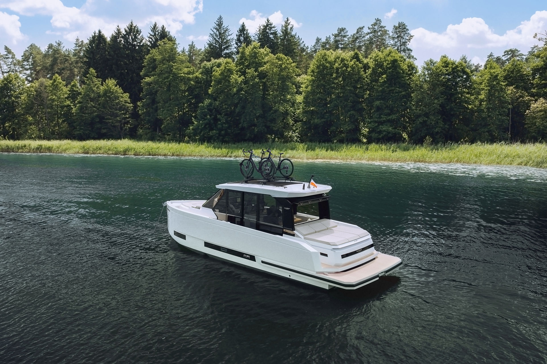 The boat at rest on a lake with bicycles carried on the hardtop