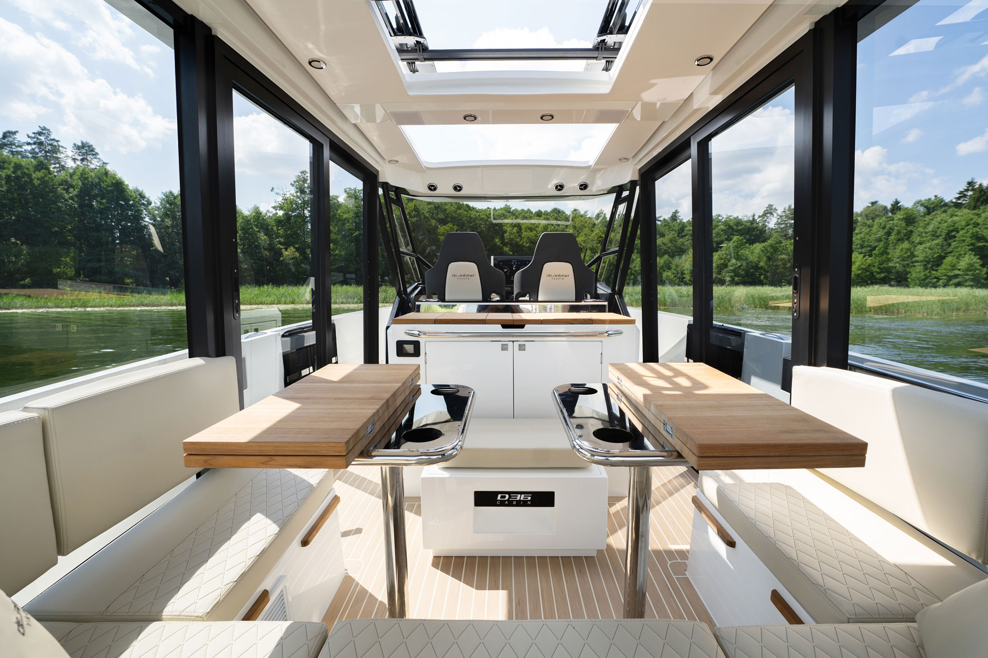 Inside the cabin looking forward to the helm, the roof open above