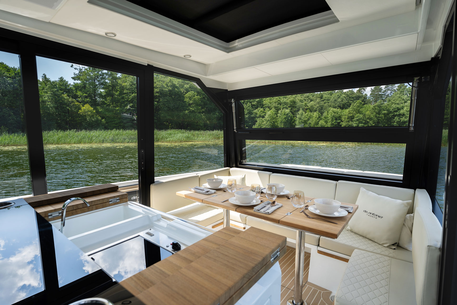 The cabin table laid for a meal, looking out over the water