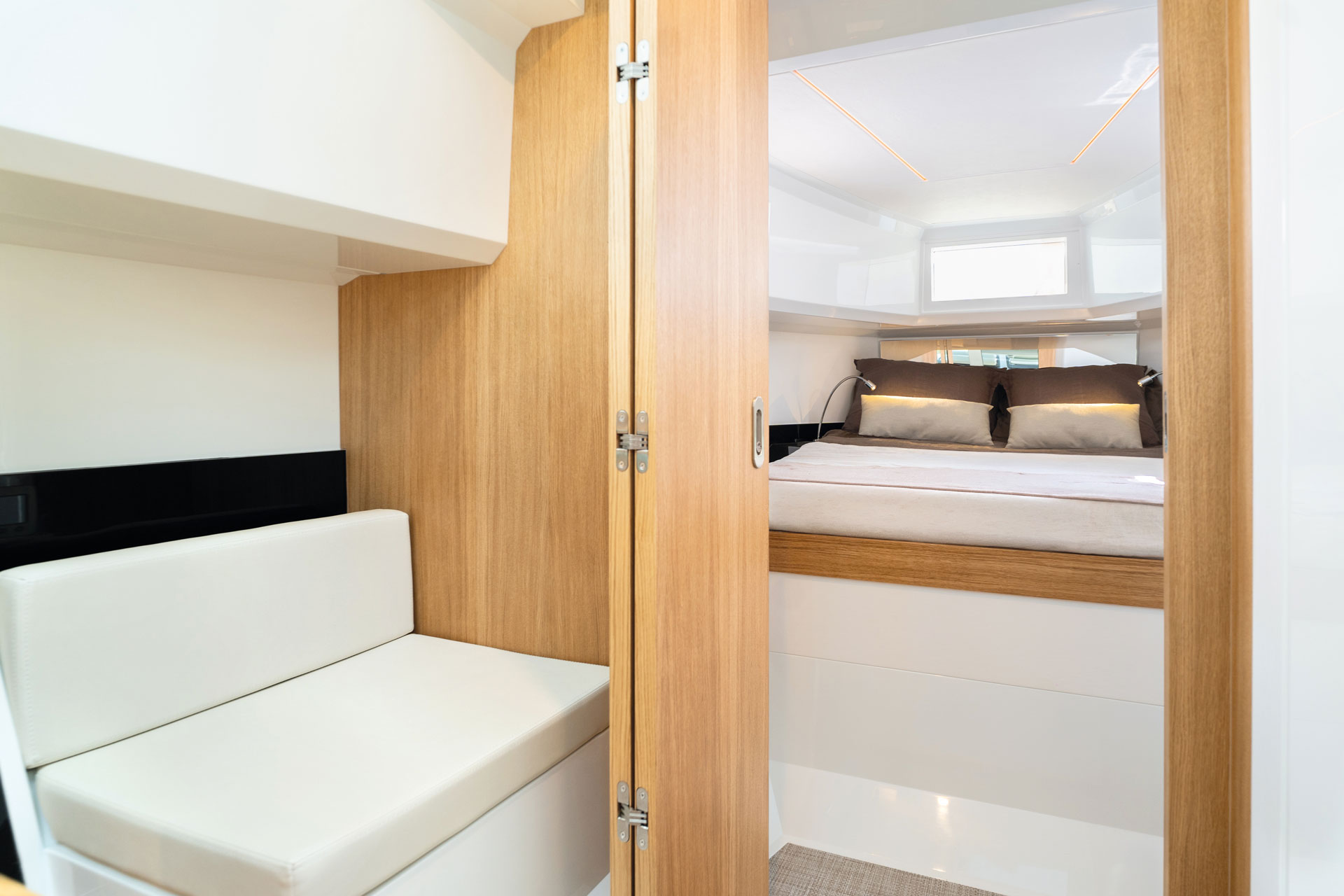 Below deck, a sofa with a berth visible through the open door