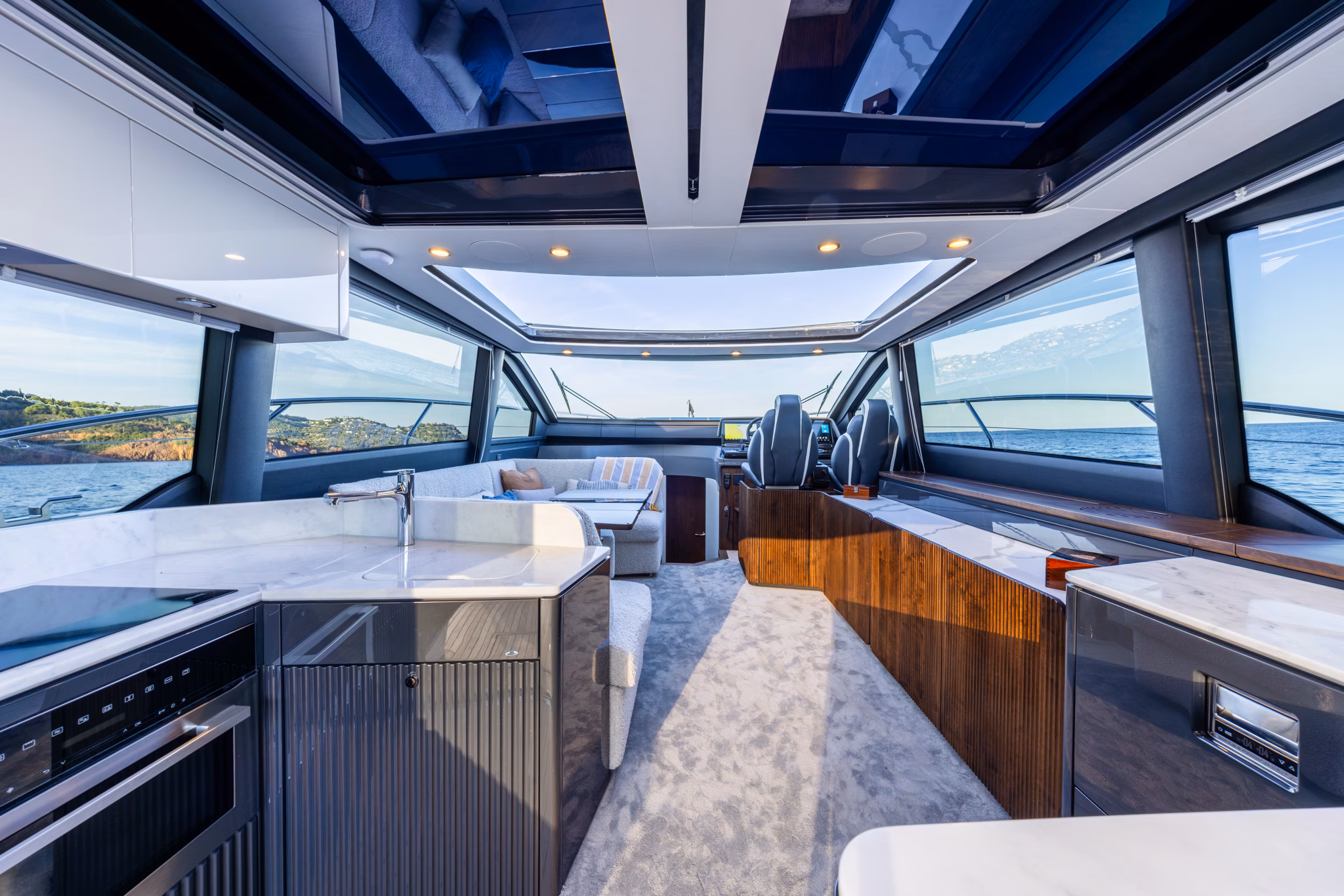 The saloon looking forward past the galley to the helm, sunroof open
