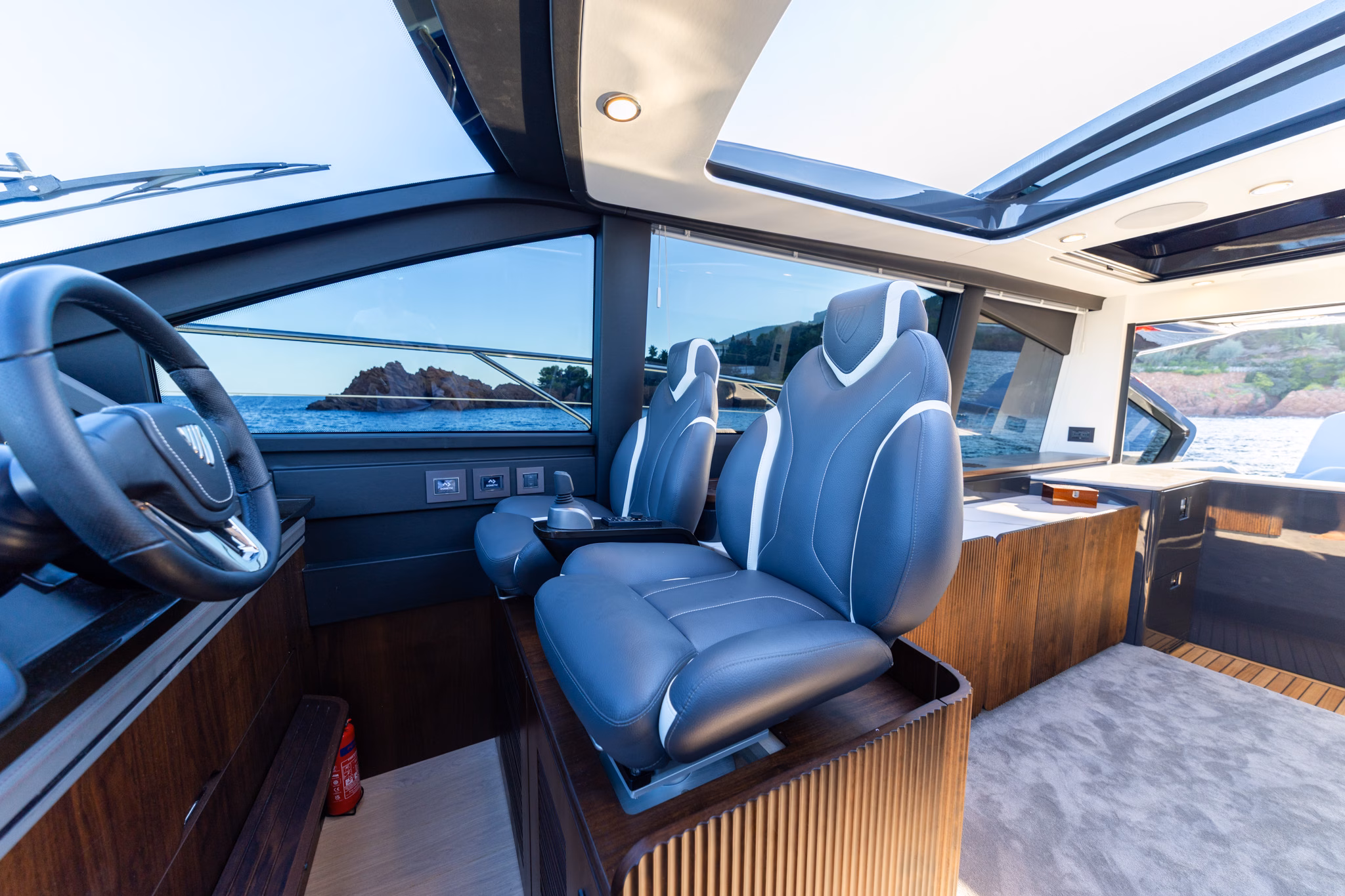 The helm seats and wheel under the opening roof