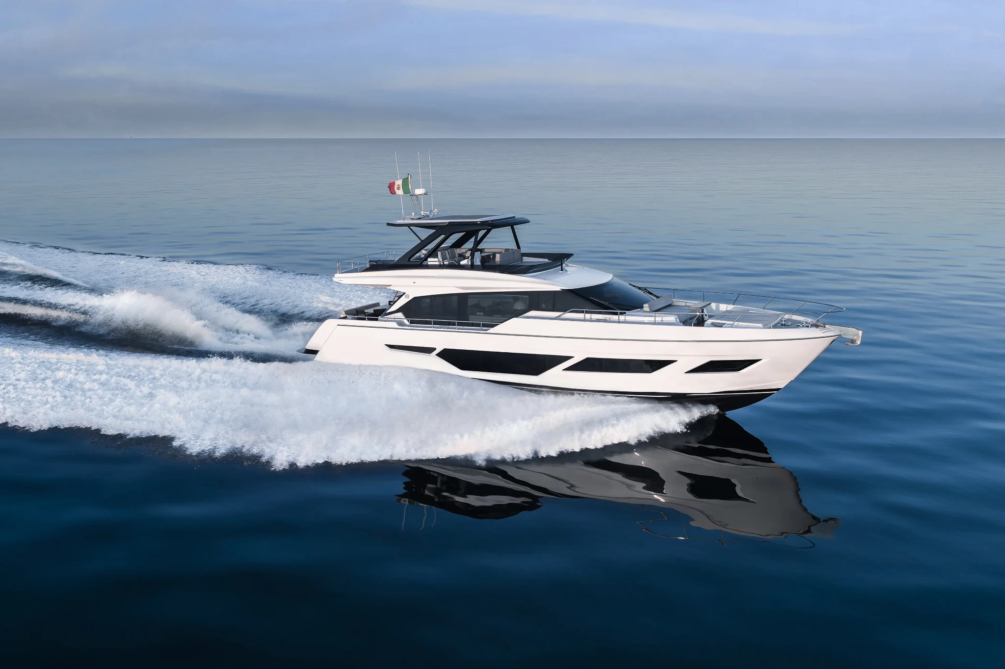 The 720 running from right to left at speed on calm water, her bow wave curling white and an Italian ensign flying from the flybridge