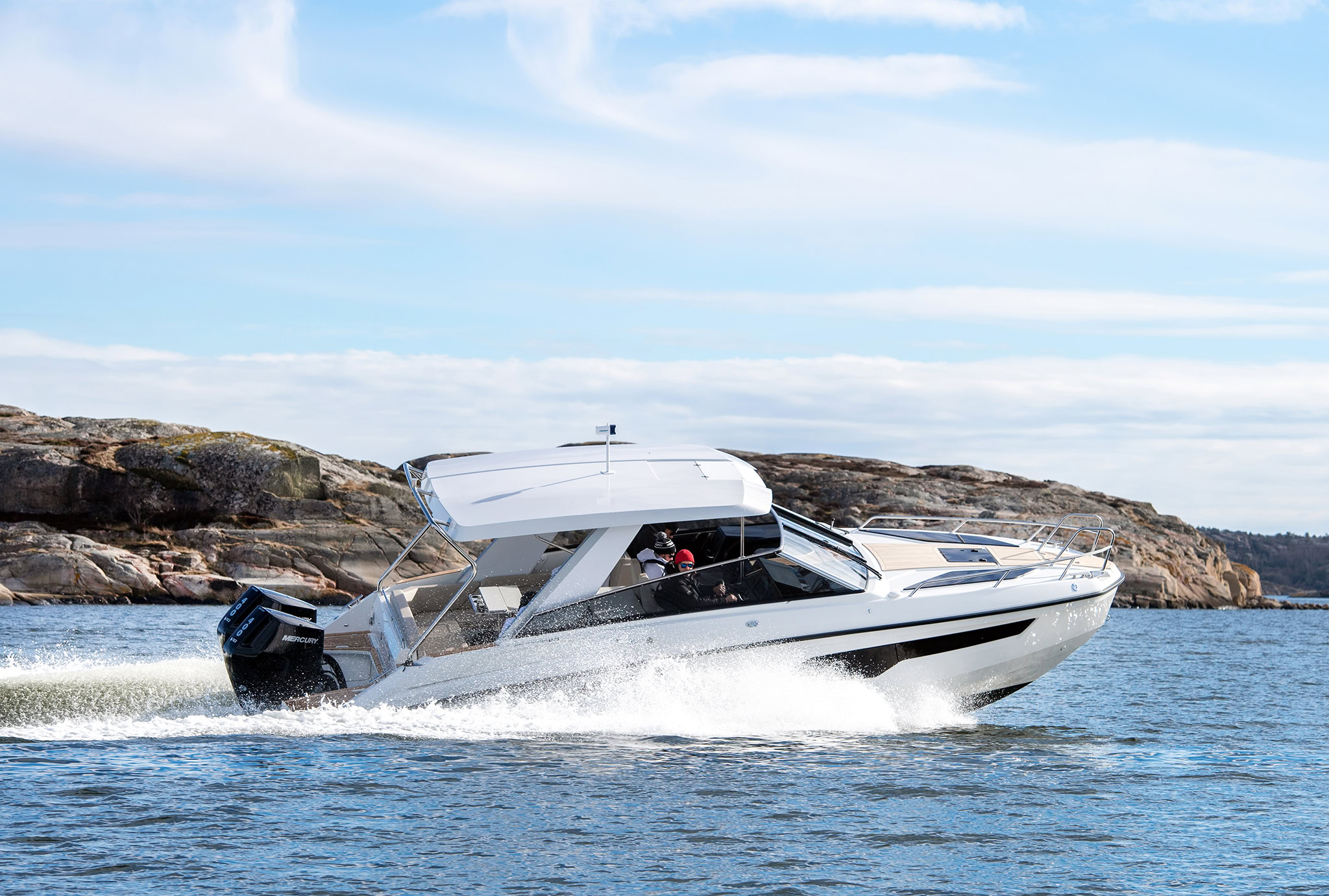 Running past bare granite rocks, two people at the helm
