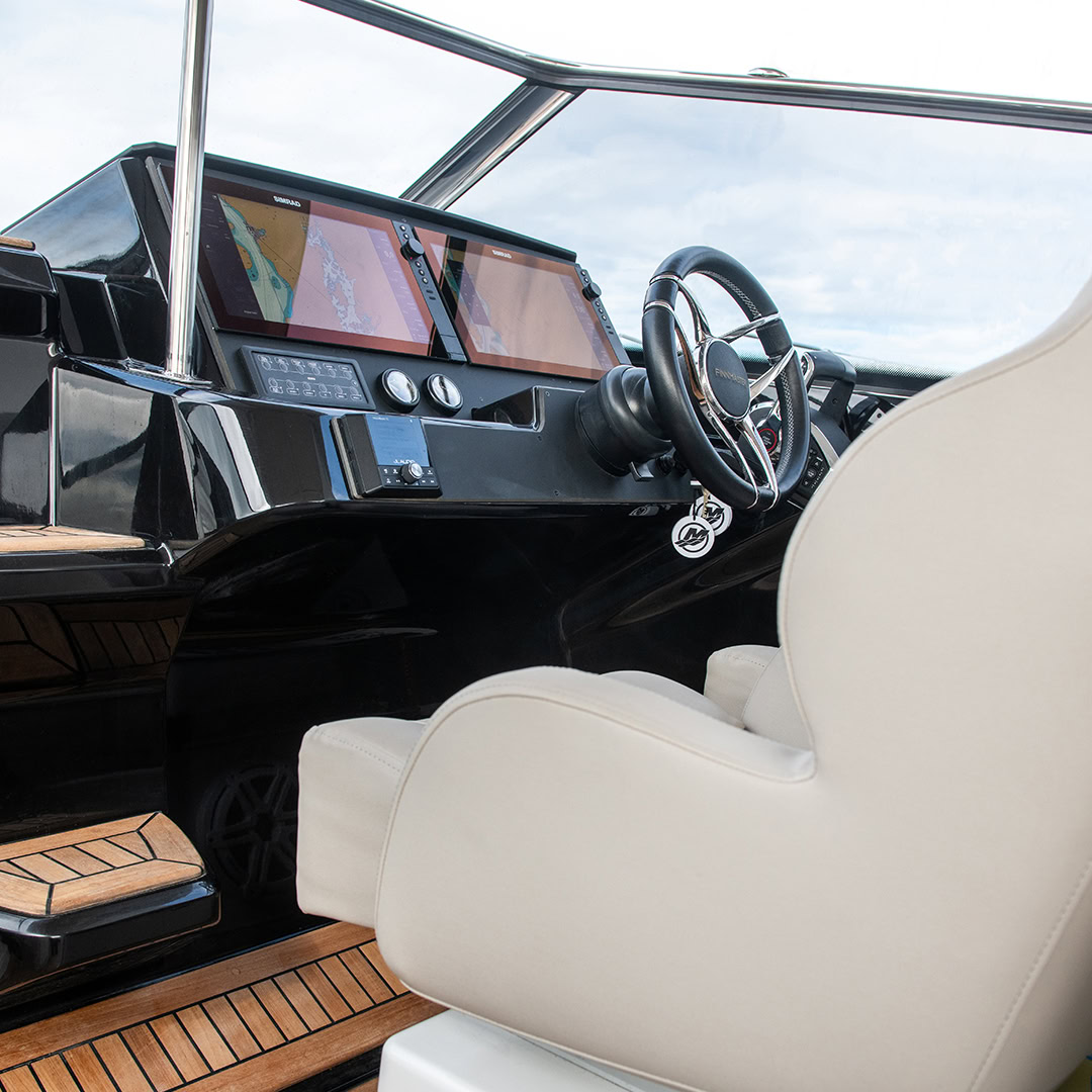 The helm with its wheel, twin displays and a white companion seat