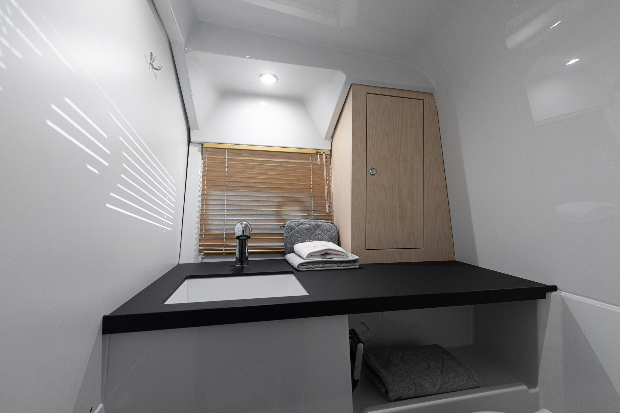 A cabin below with a counter, basin and folded towel