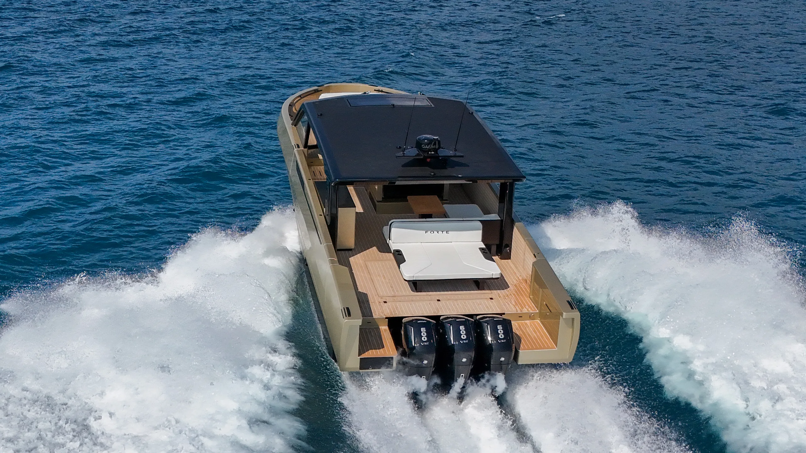 Running away from the camera, the three outboards throwing a wake