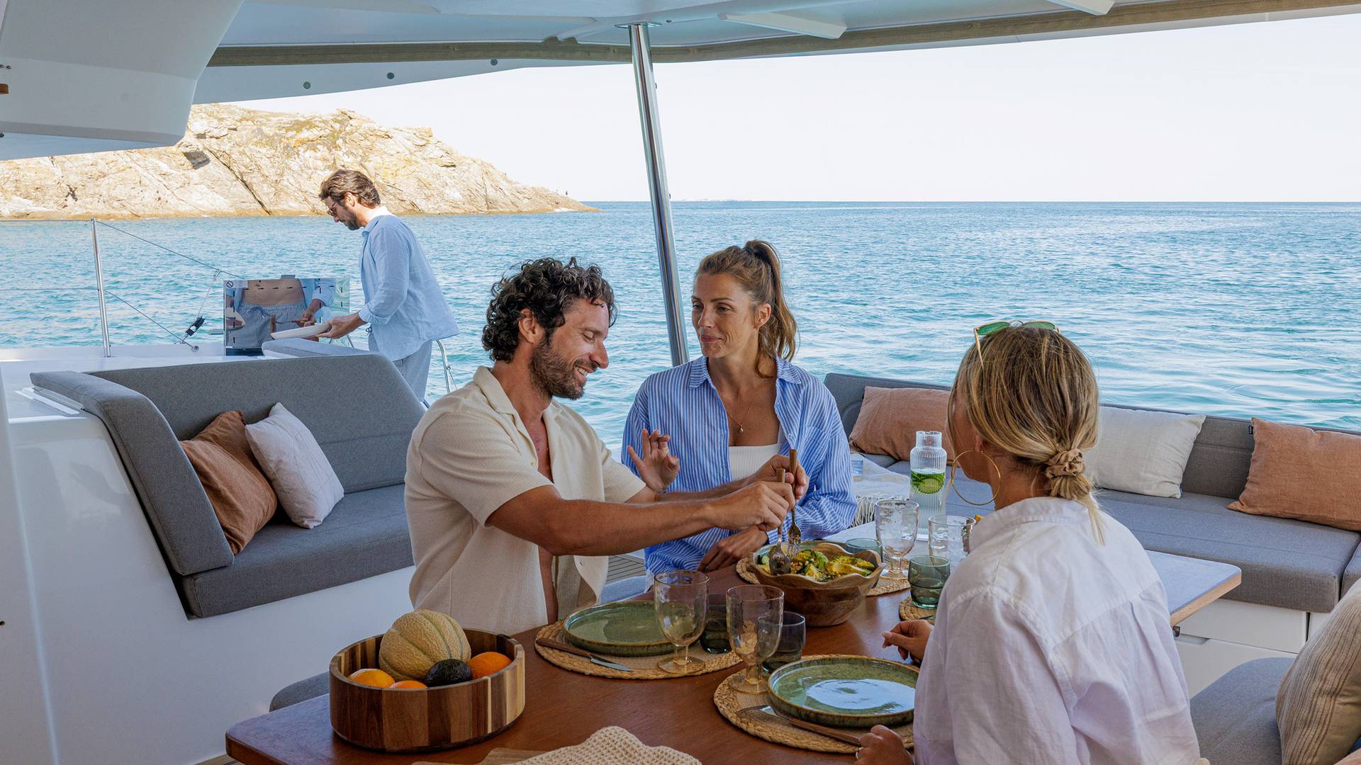 Guests around the cockpit table with the outdoor worktop behind them
