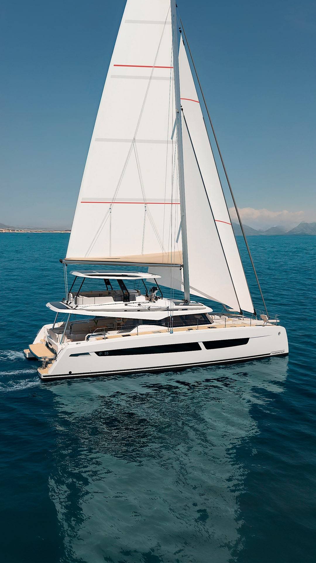 The catamaran under full sail on open water