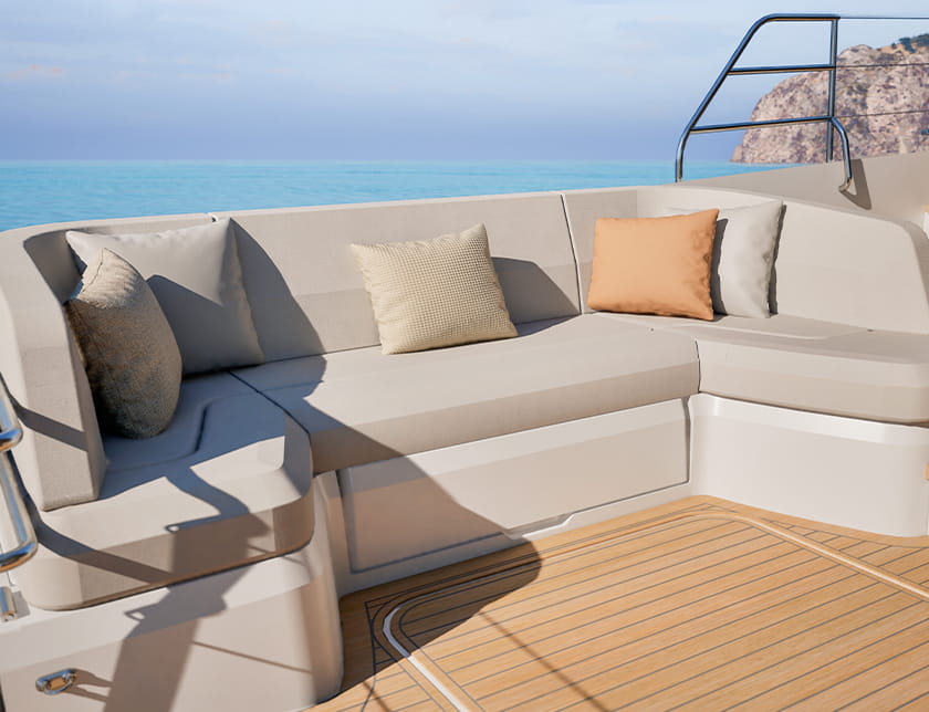 The cockpit settee running round two sides of a teak deck, the shore beyond