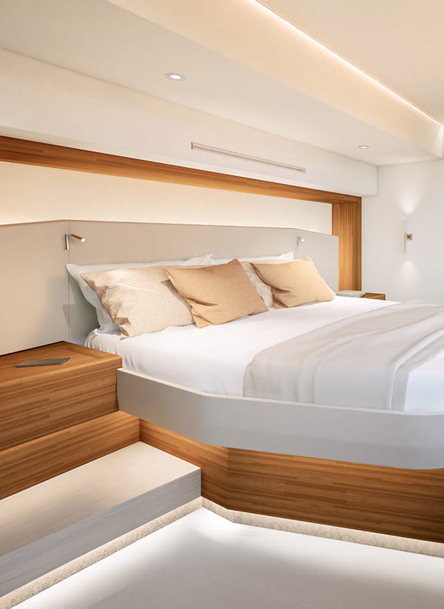 A double berth against a padded headboard with a shelf above it