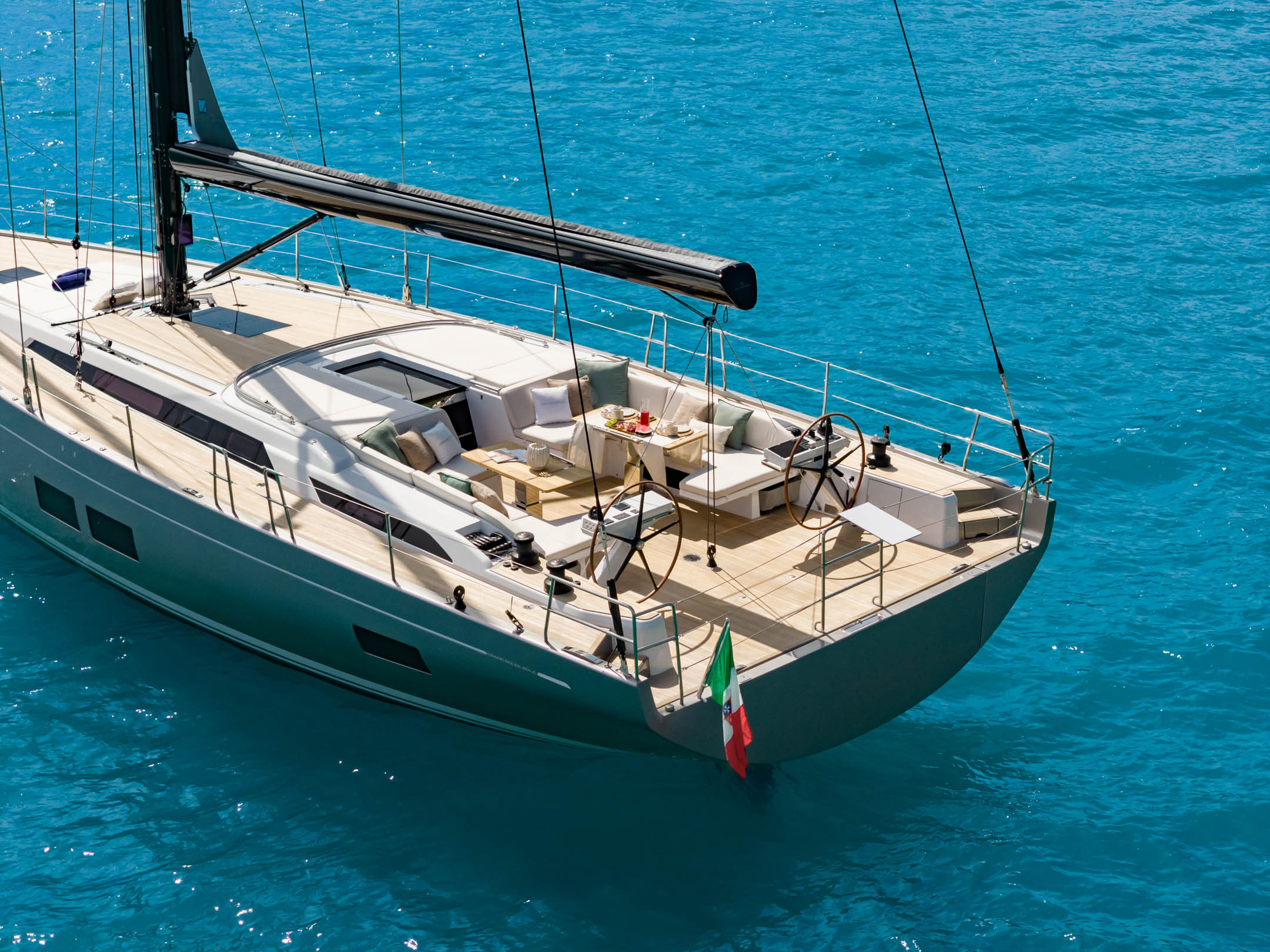 At anchor in flat water, the dark hull against blue