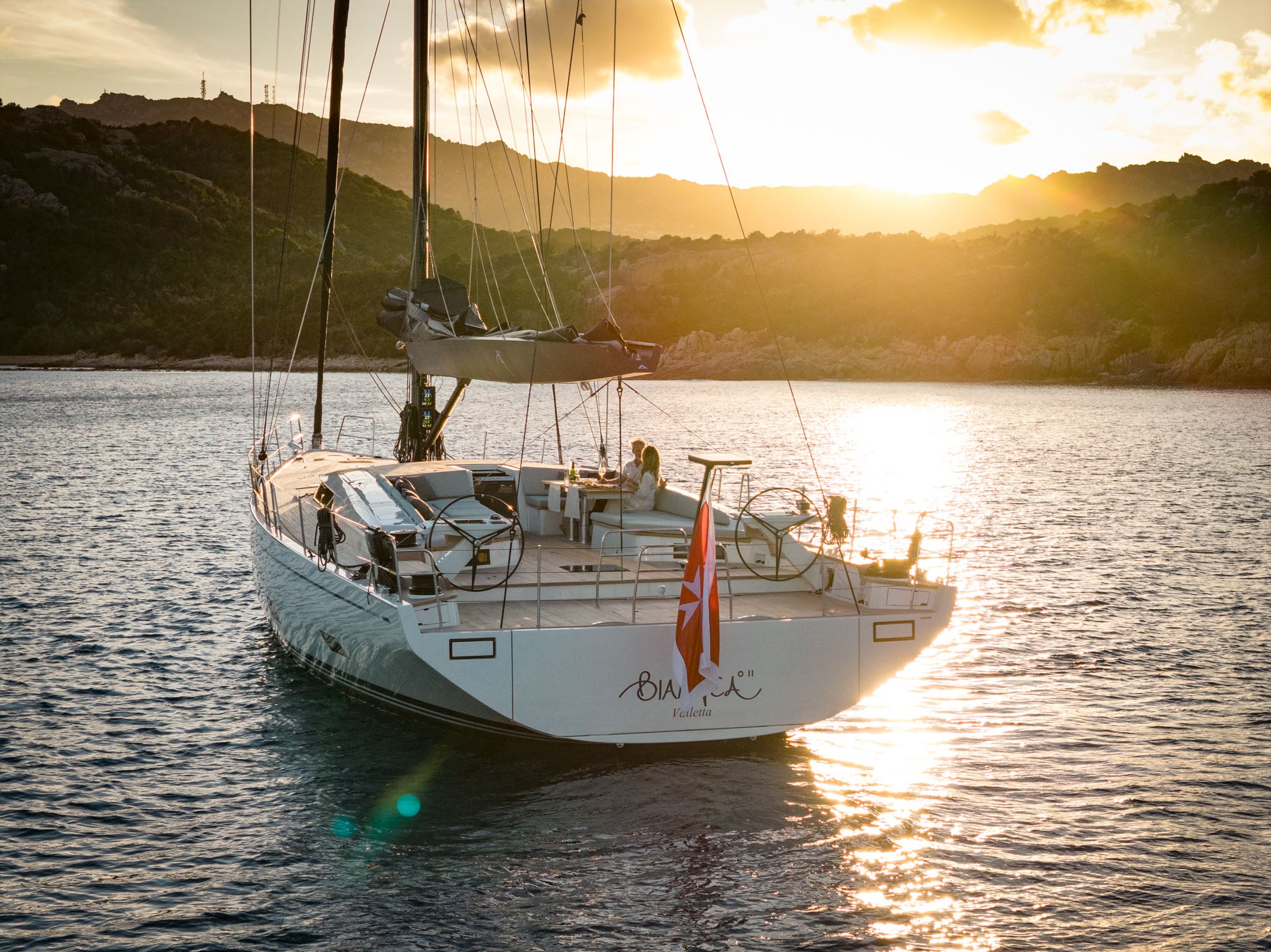 Lying to her anchor with the sun low behind the rig