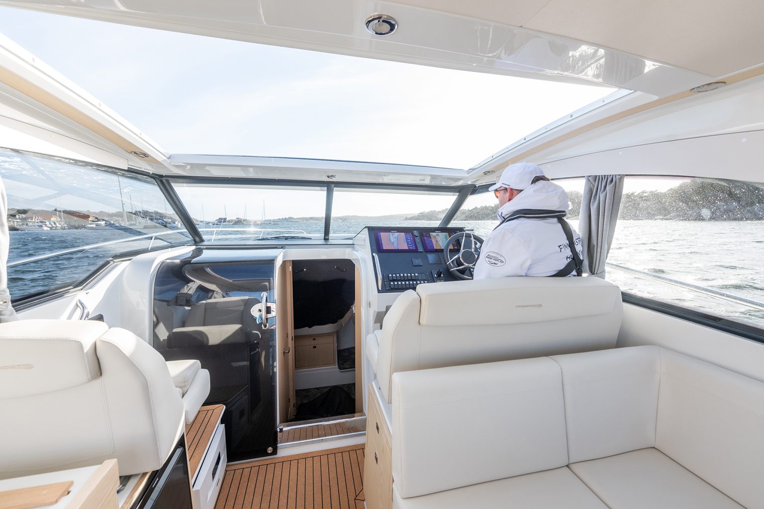 The helm seen from the cockpit, a figure at the wheel
