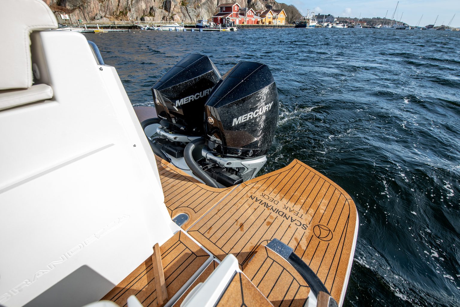 Twin Mercury outboards on the transom beside the teak bathing platform