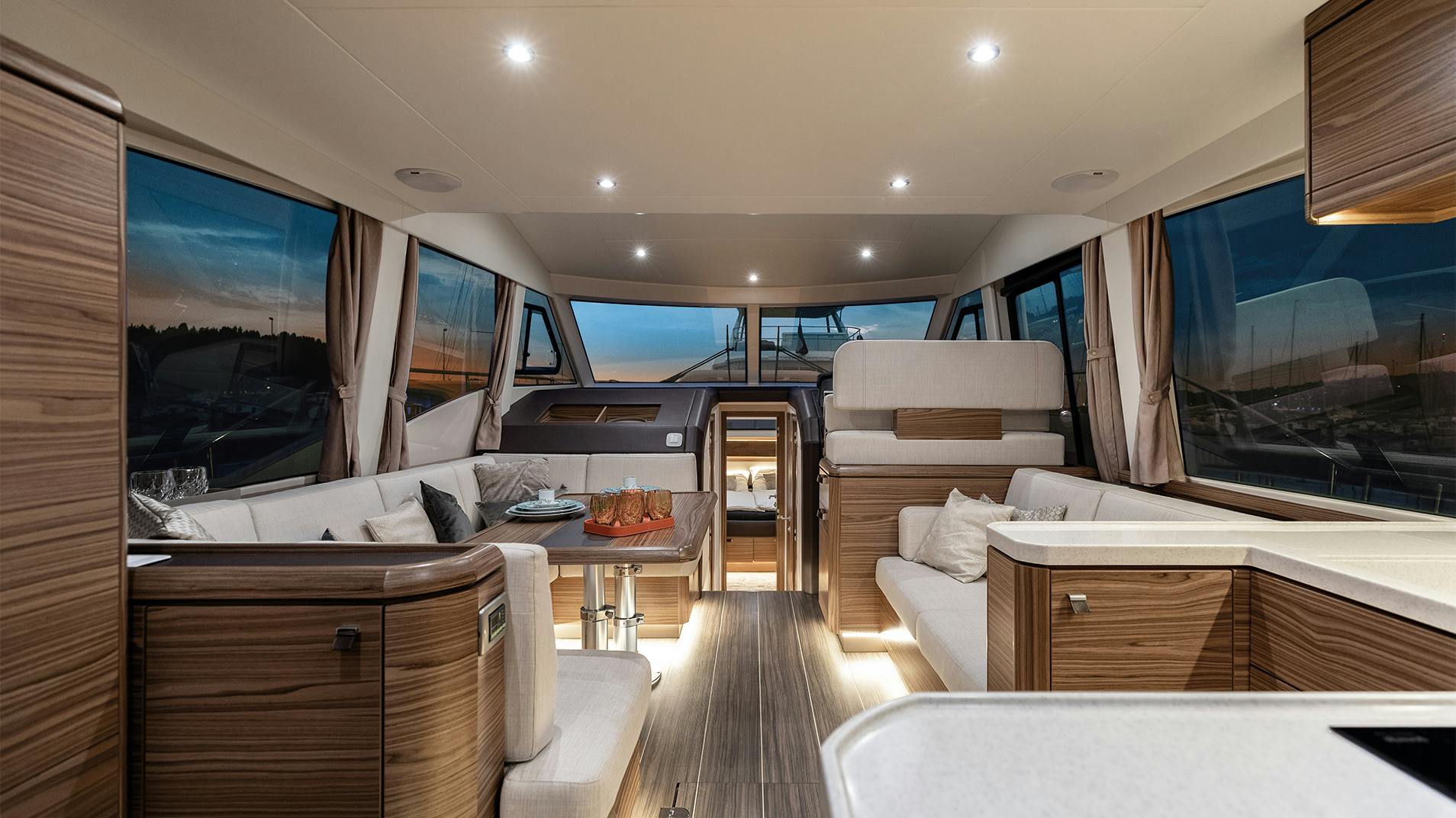 The salon looking forward, with seating along both sides and windows the length of the deckhouse
