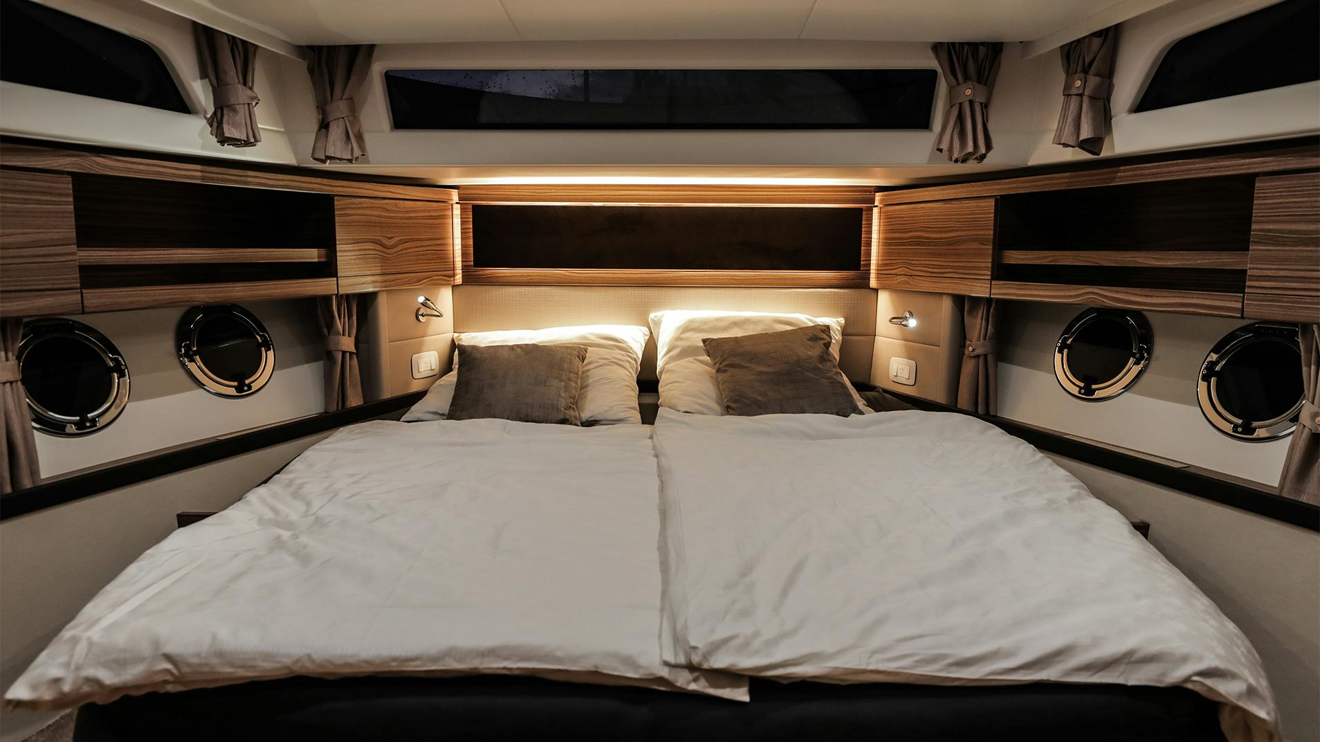 A double cabin with three portlights above the headboard
