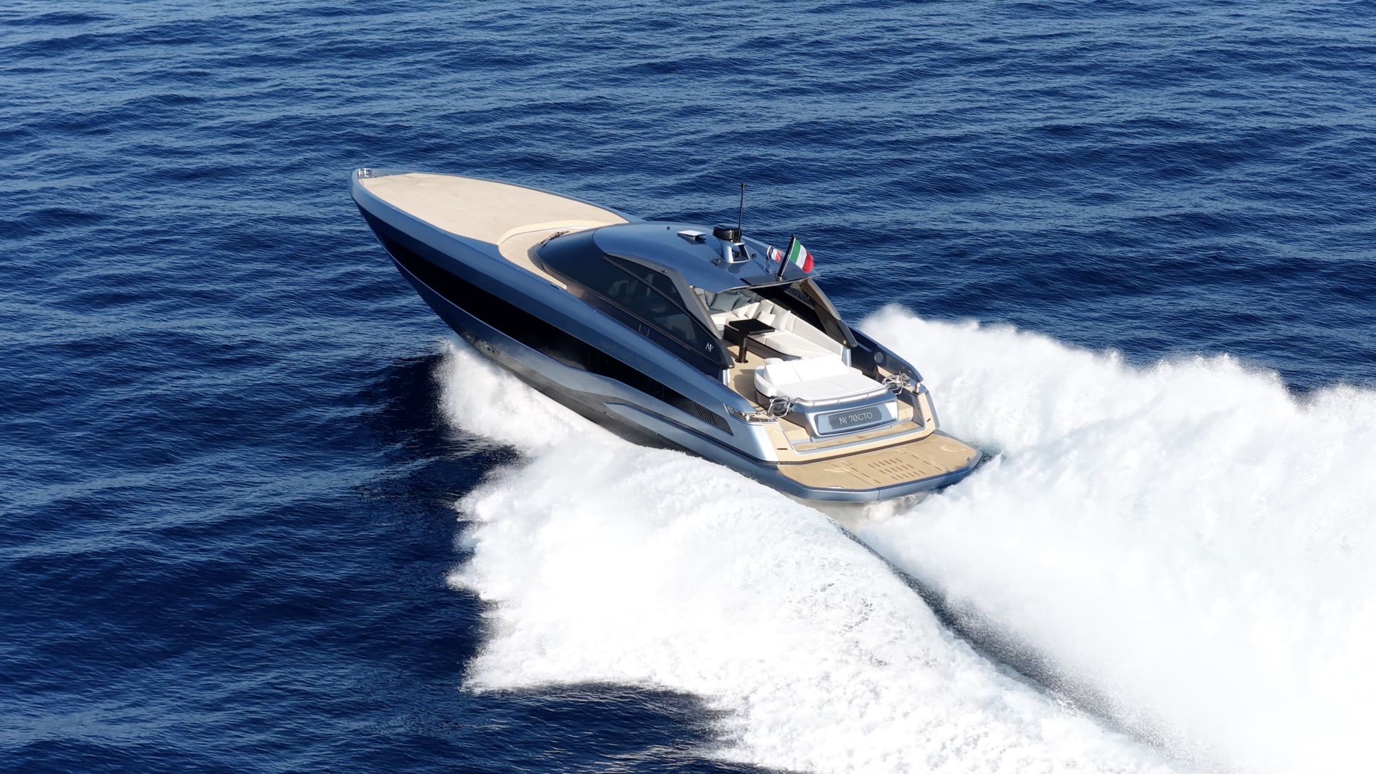 Aerial view from astern of the GTO 70 carving a turn, showing the cockpit and the teak bathing platform