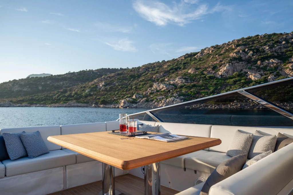 The cockpit dining area at anchor, with the U-shaped lounge and a wooden table