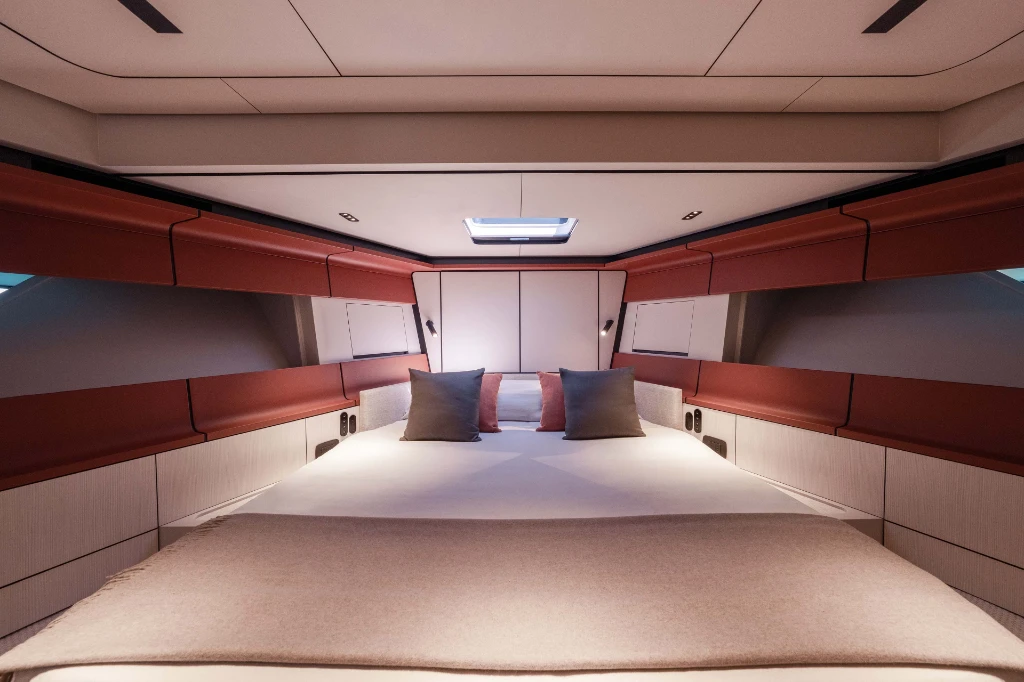 The forward cabin, the hull narrowing either side of a centred bed, with a deck hatch overhead