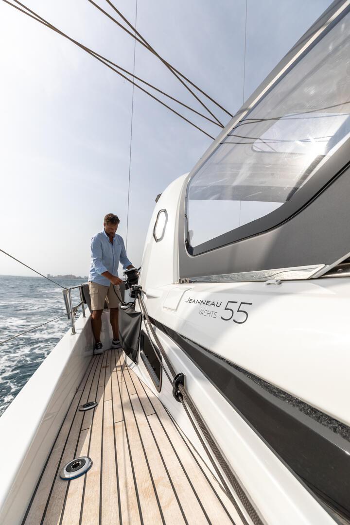 At the forward helm under the hard top, the coachroof lettered Jeanneau Yachts 55