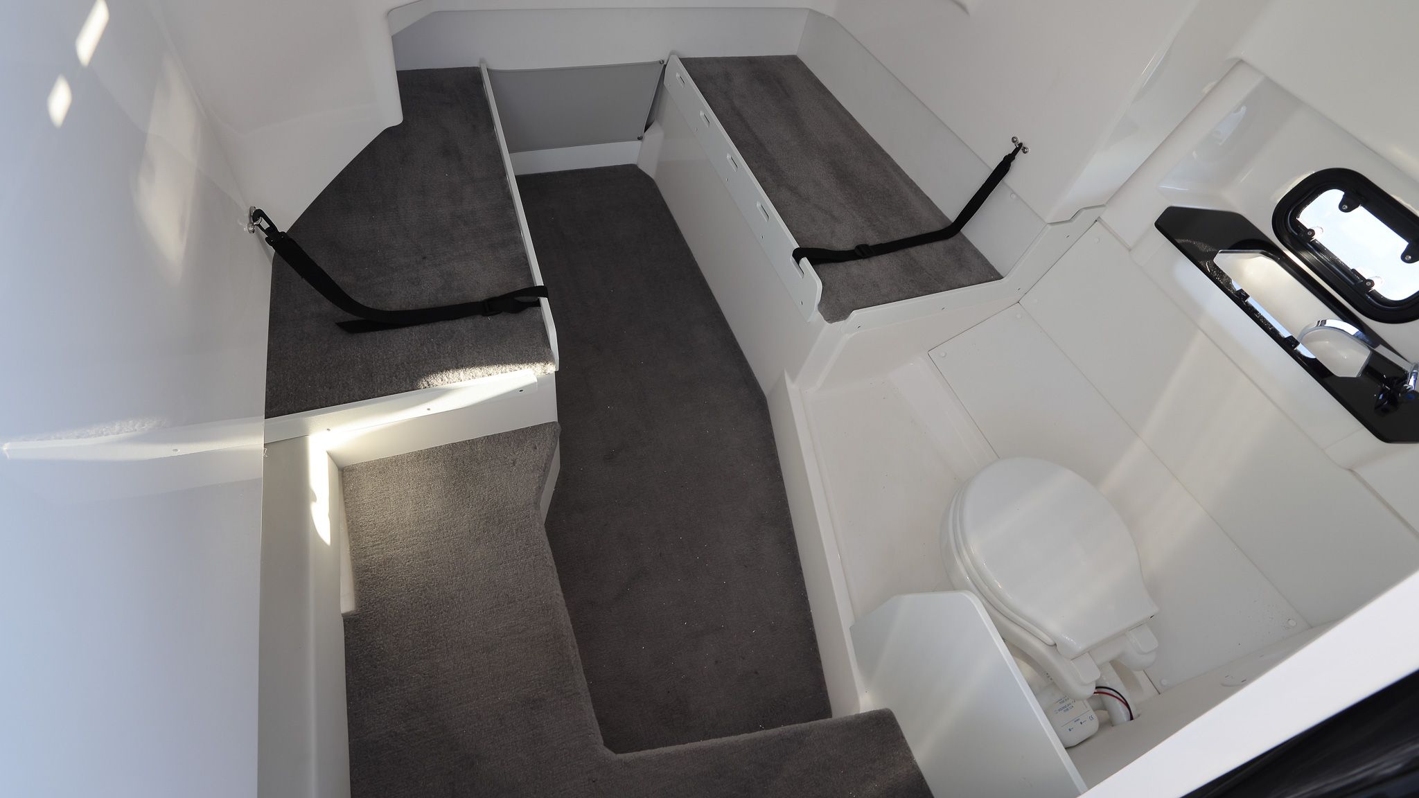 Inside the cabin, with berth cushions to both sides and a toilet forward