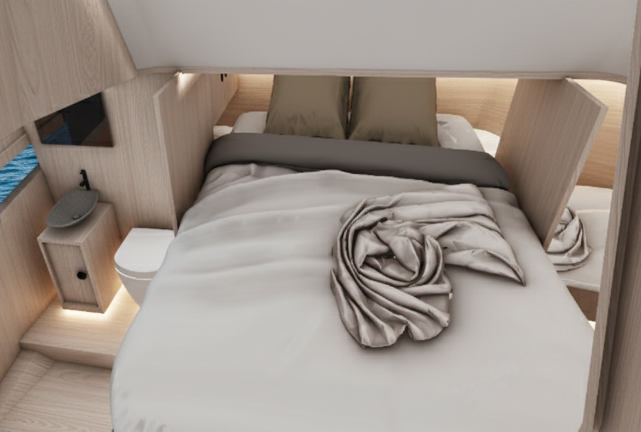 The cabin below the foredeck in pale oak, a double berth with olive pillows and a rolled throw, a small basin on a cabinet to one side and a marine toilet beside it