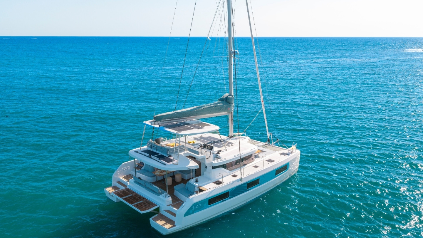 The Lagoon 47 at rest from the air, its flybridge with solar panels, seating and a bimini above the aft cockpit