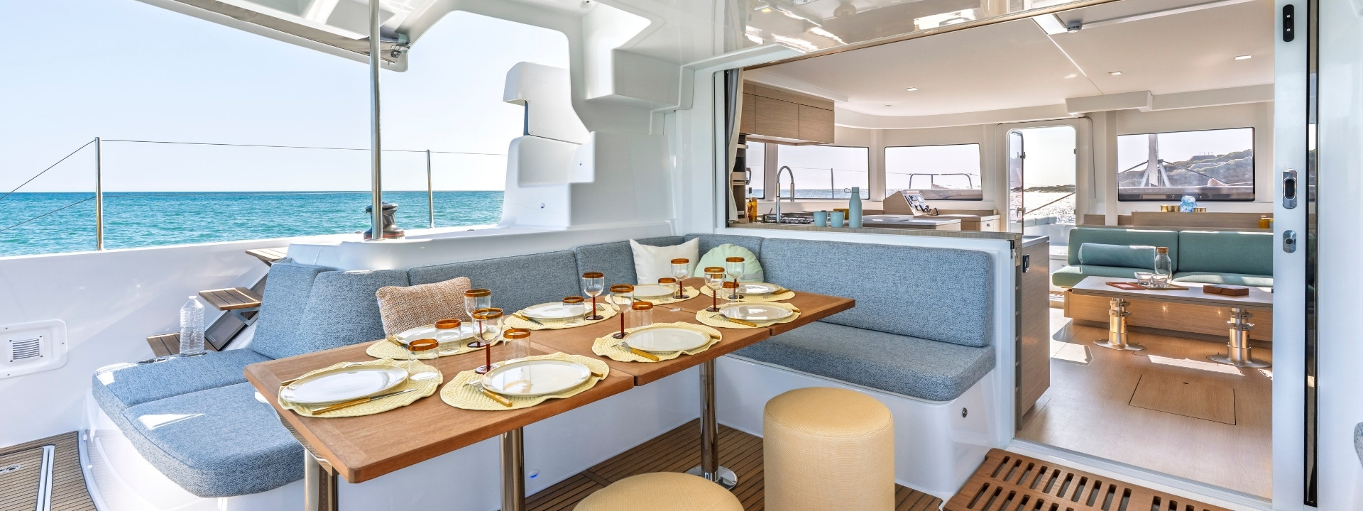 The aft cockpit dining table laid for lunch, with the sliding door open into the saloon and galley