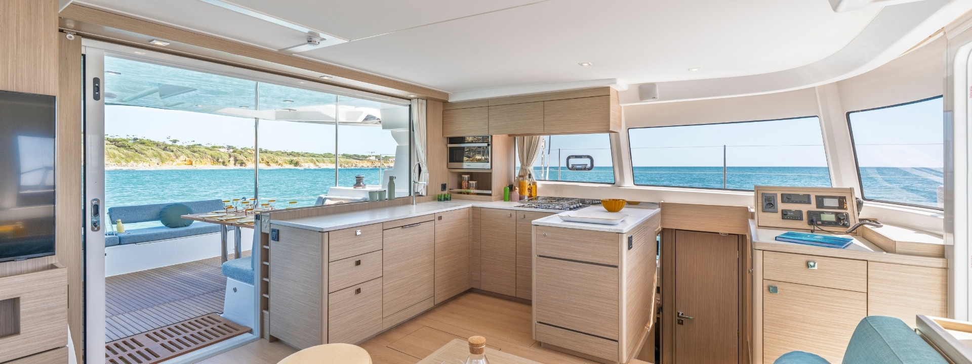 The galley in light oak, with a view through the open aft door to the cockpit
