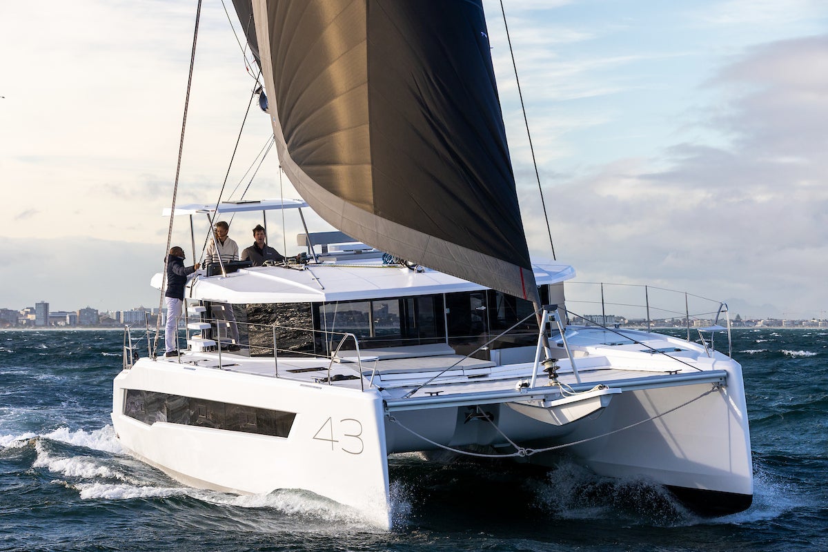 The Leopard 43 under main and headsail with a city waterfront behind