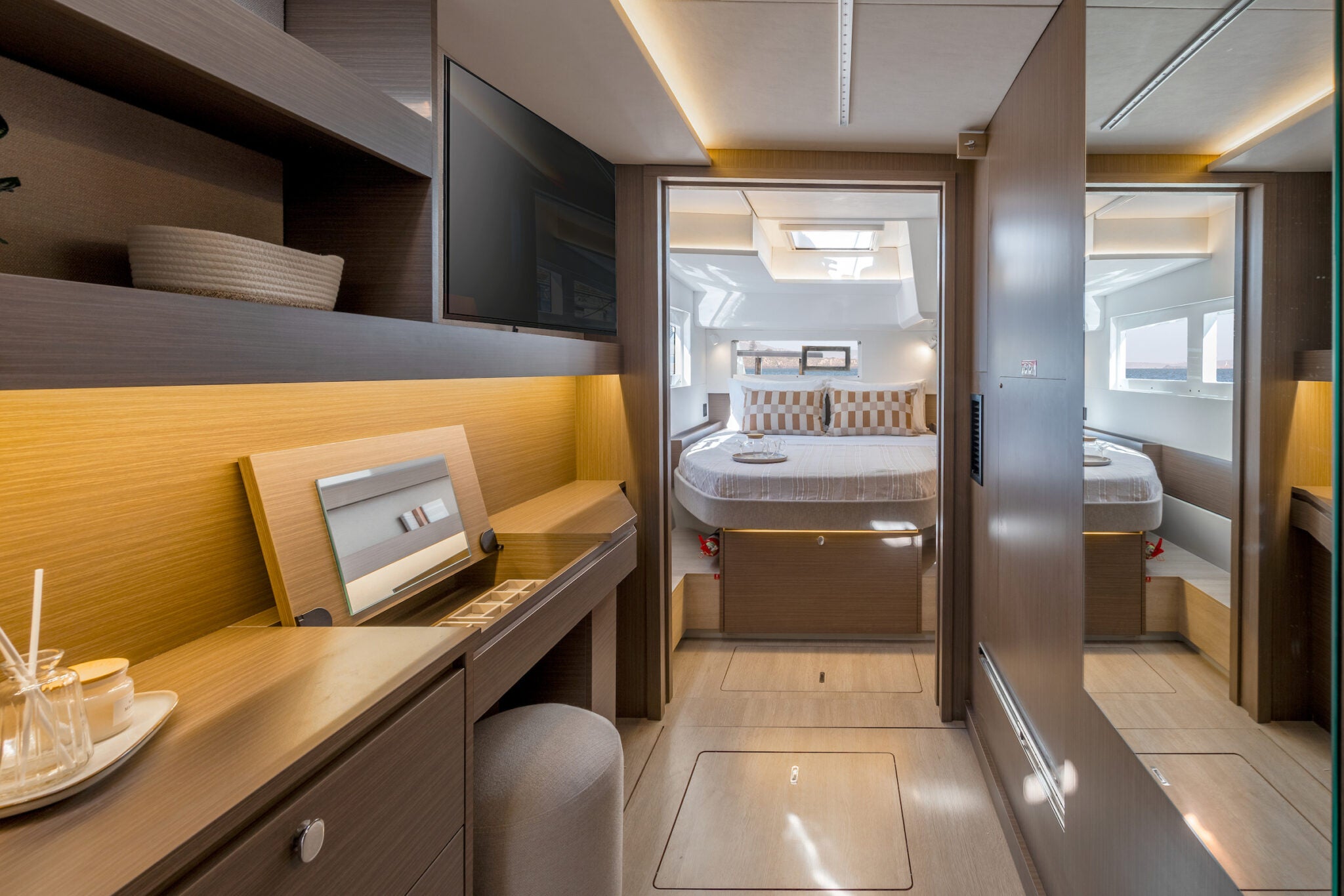 A cabin with a double berth, a desk and a doorway through to the heads